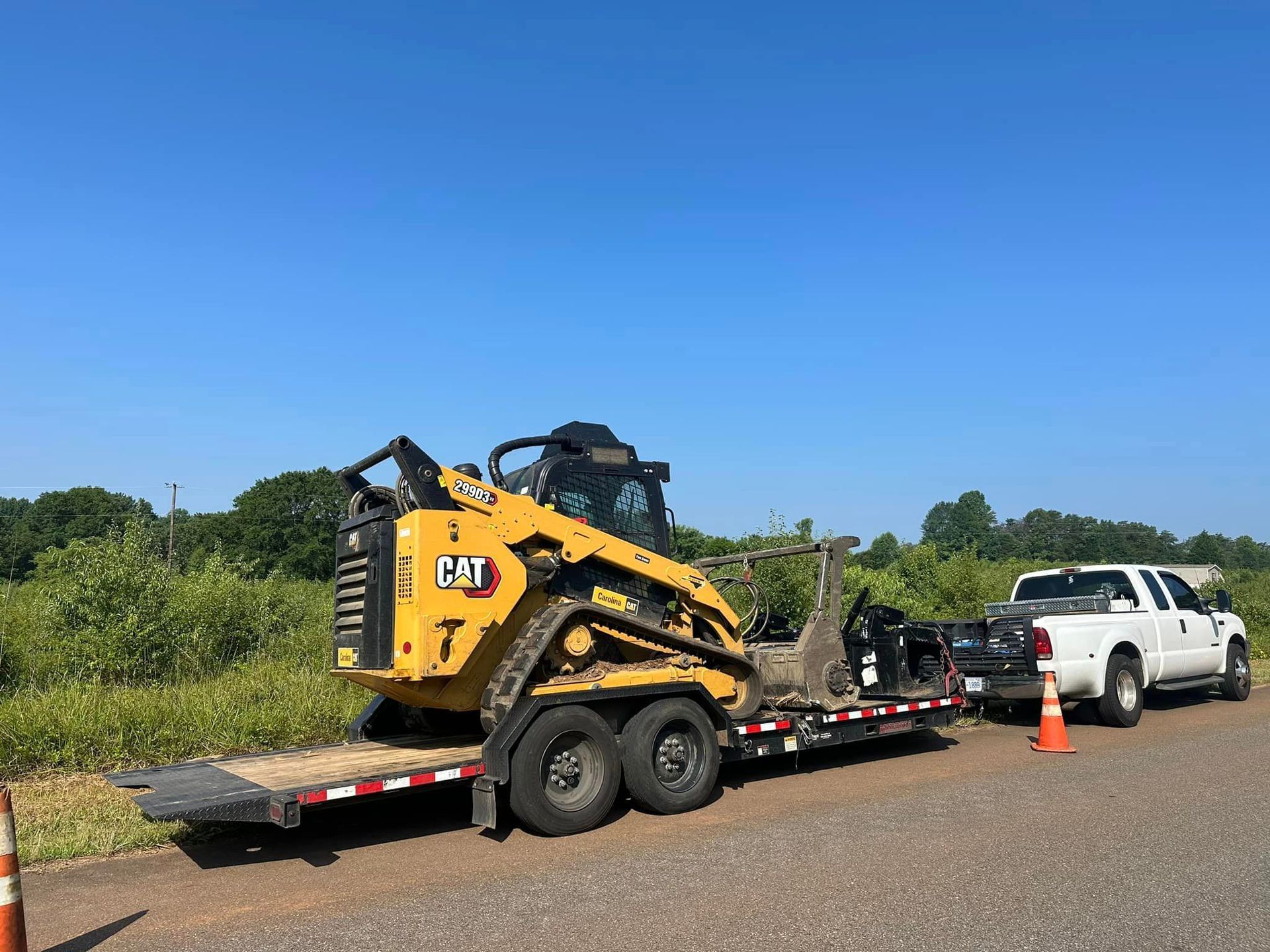 A truck is towing a bulldozer on a trailer.
