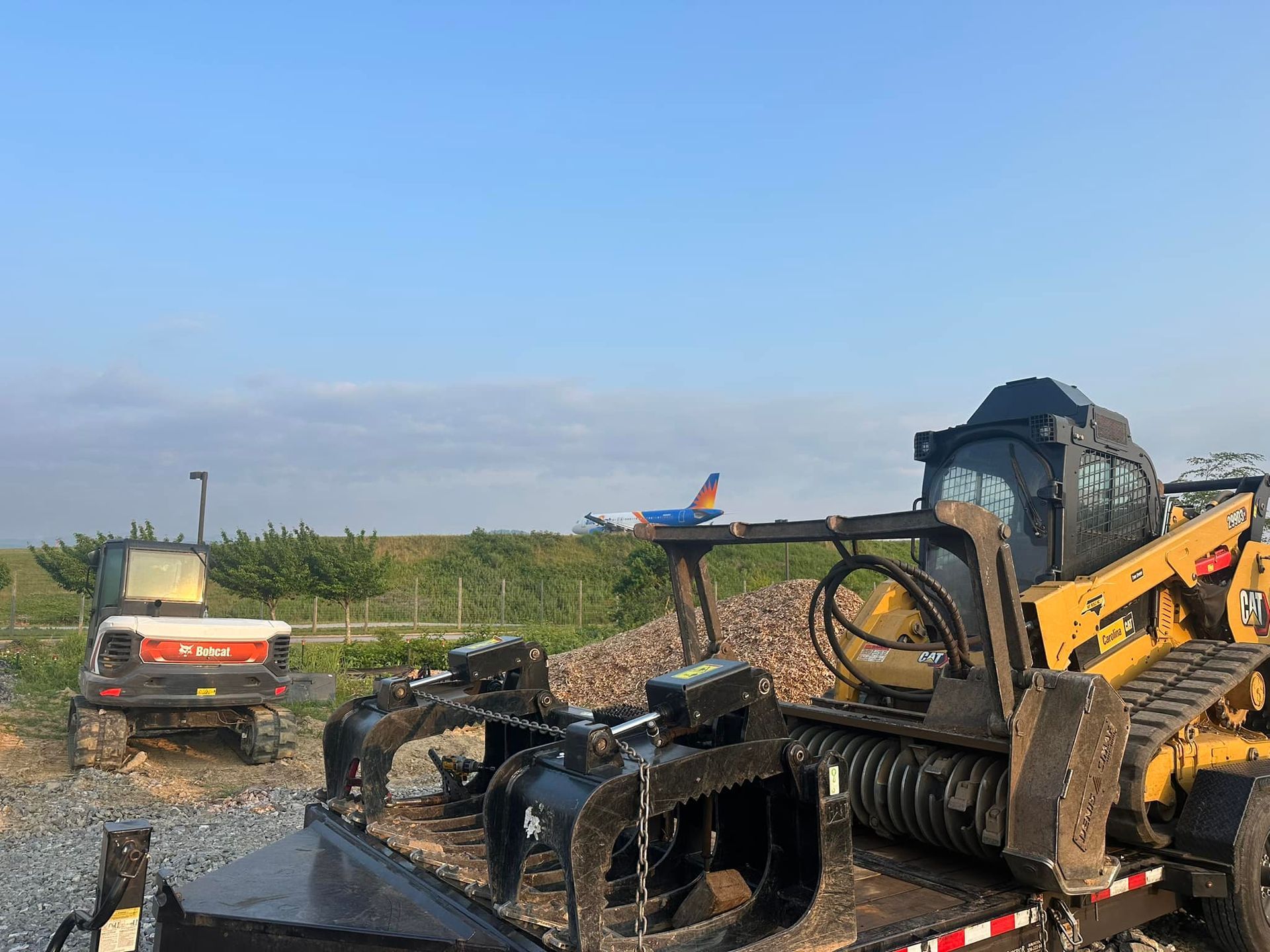 A couple of tractors are parked next to each other in a field.