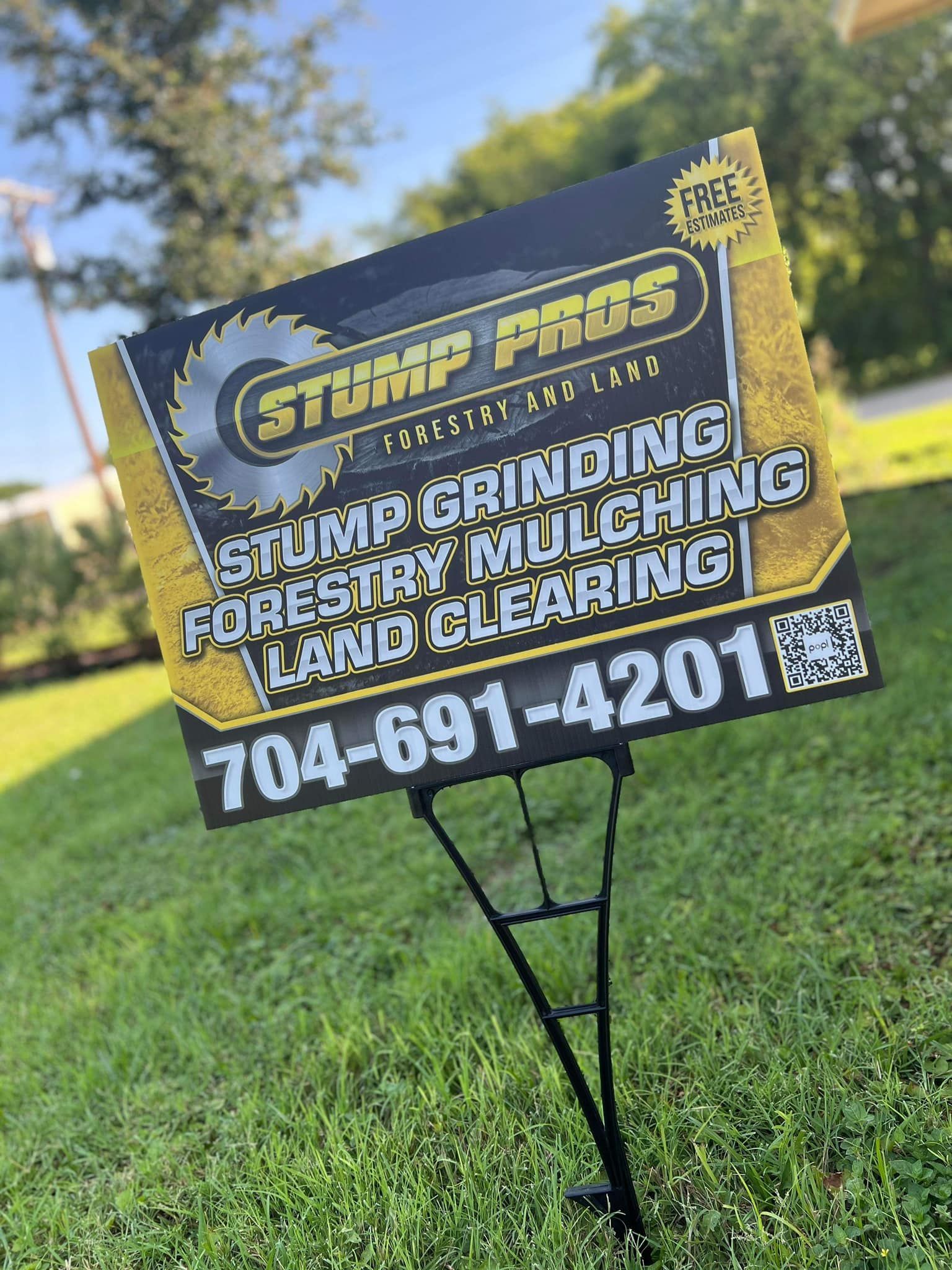 A sign is sitting on top of a lush green field.