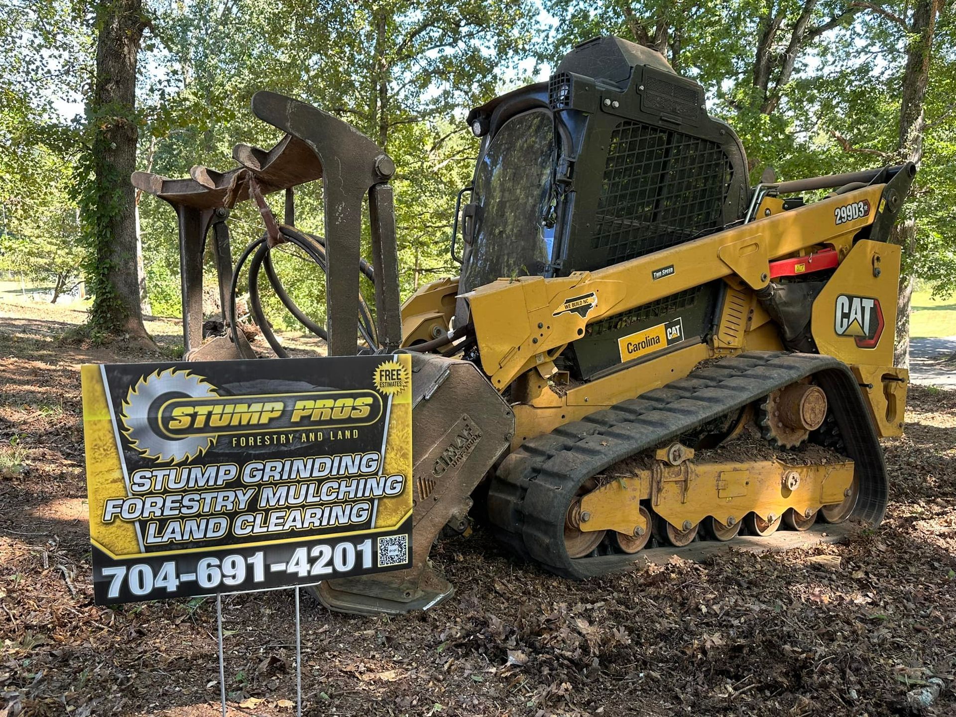 A bulldozer is parked next to a sign that says stump pros.
