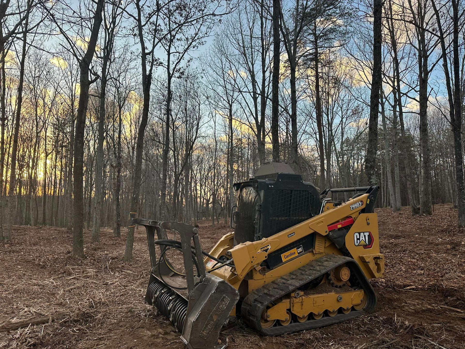 A bulldozer is sitting in the middle of a forest.