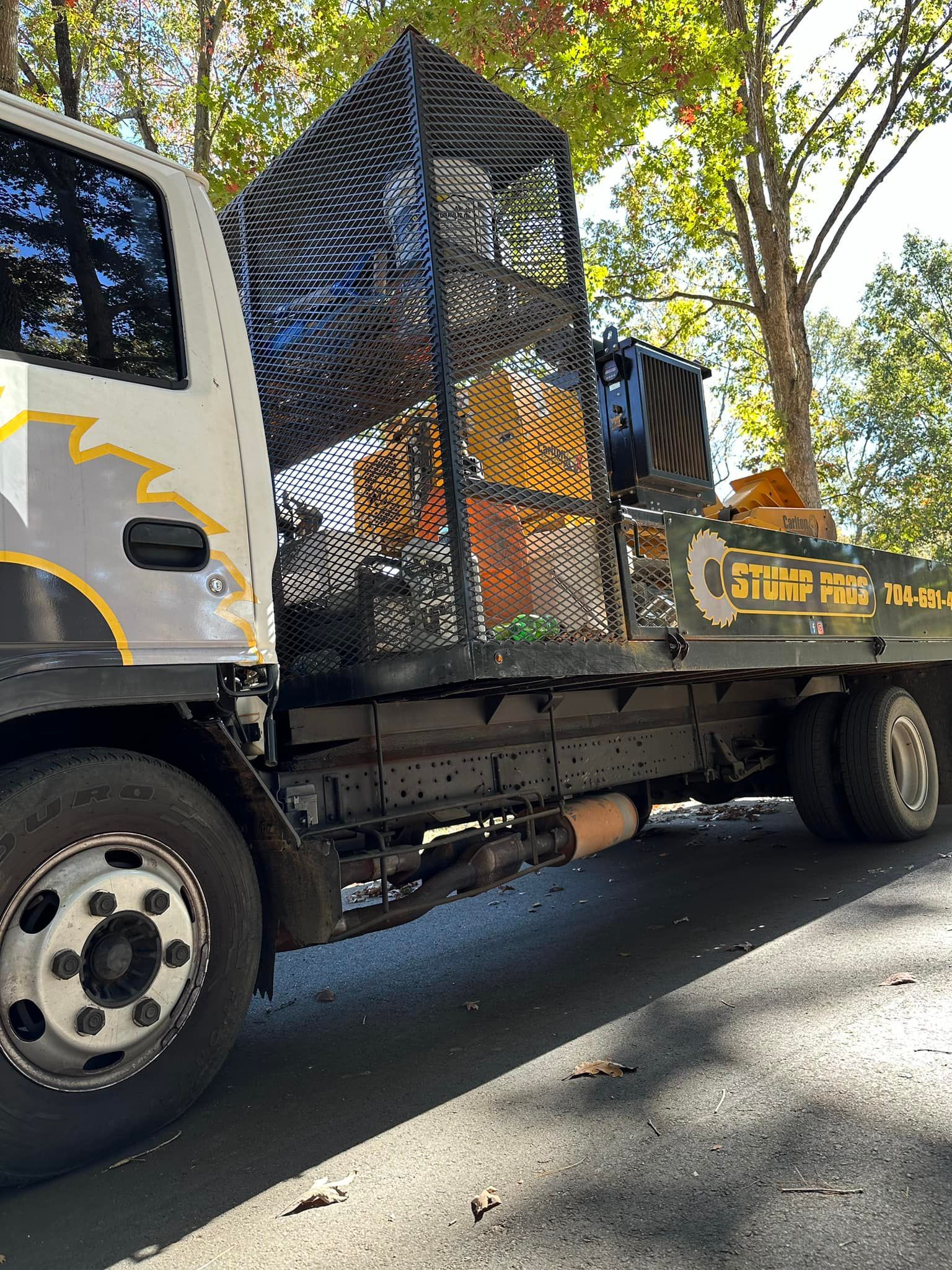 A tow truck with a cage on the back is parked on the side of the road.