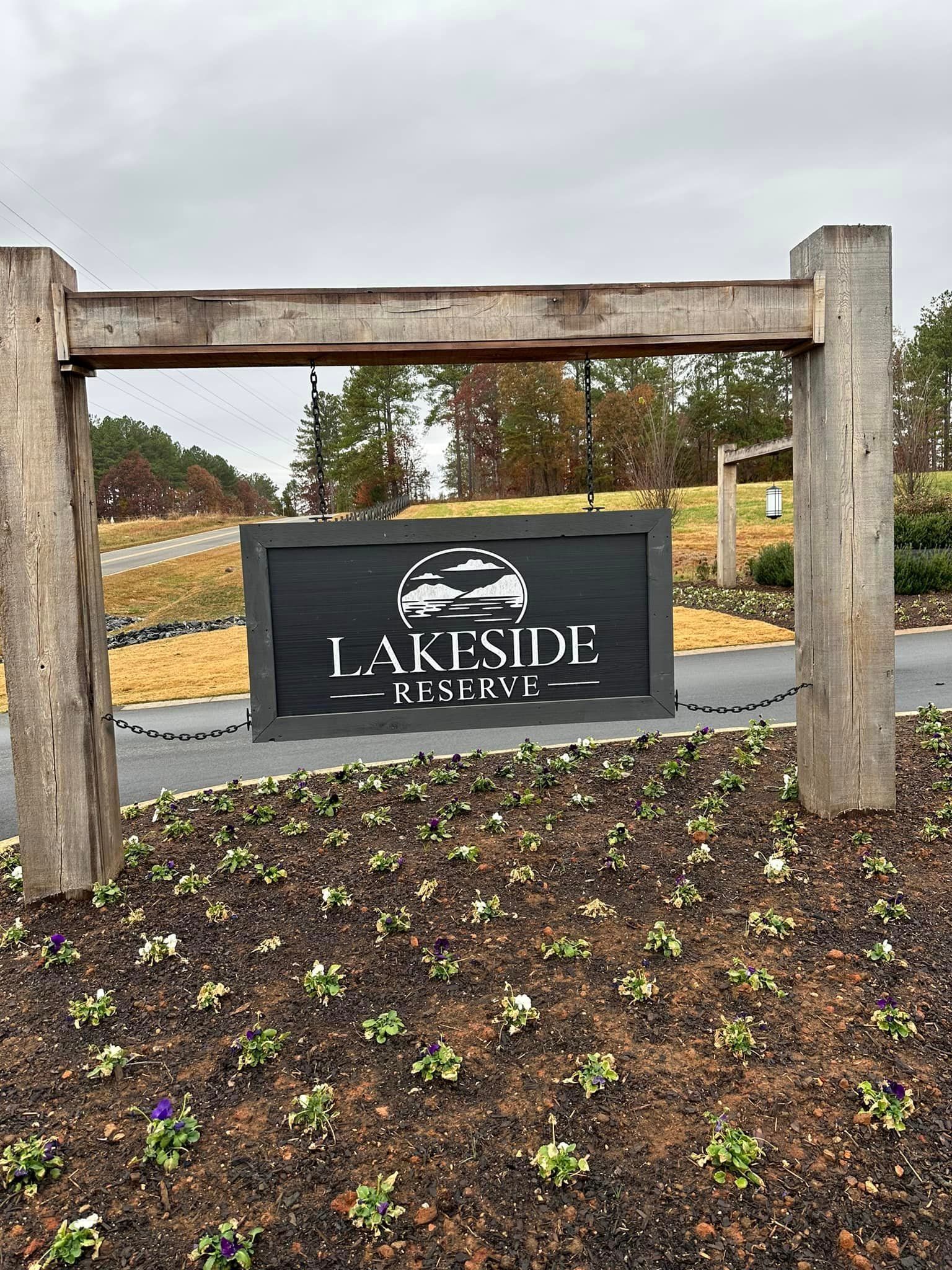 A sign that says lakeside on it is surrounded by flowers.