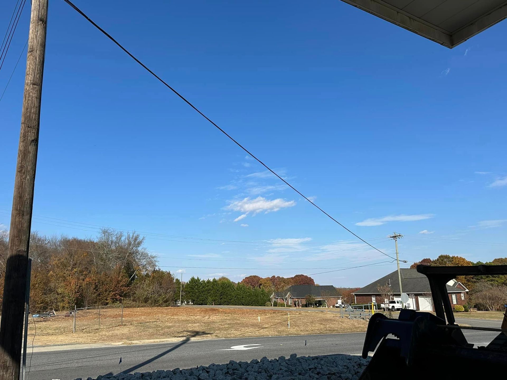 A golf cart is parked on the side of the road with a blue sky in the background