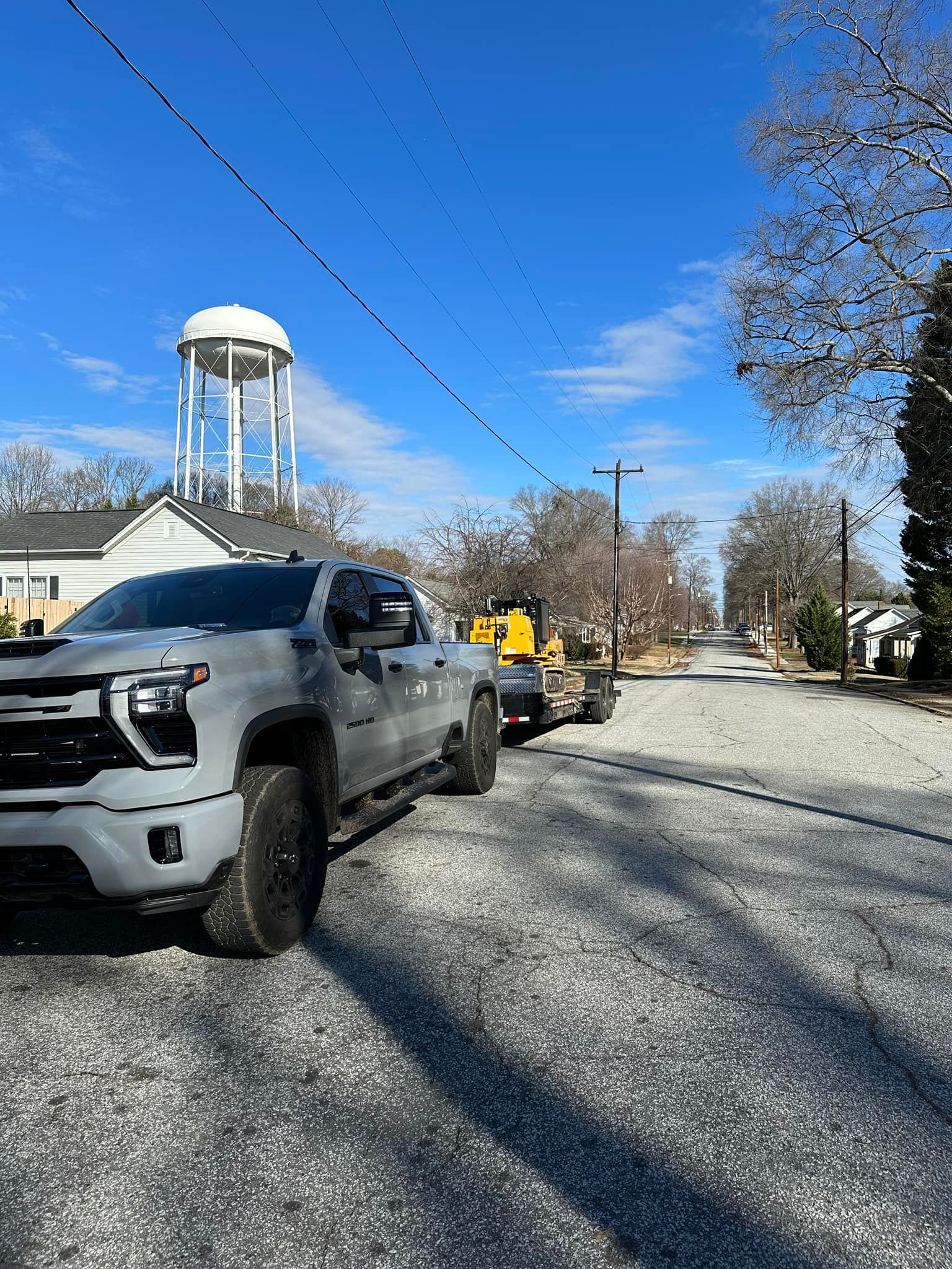 A white truck is parked on the side of a gravel road.