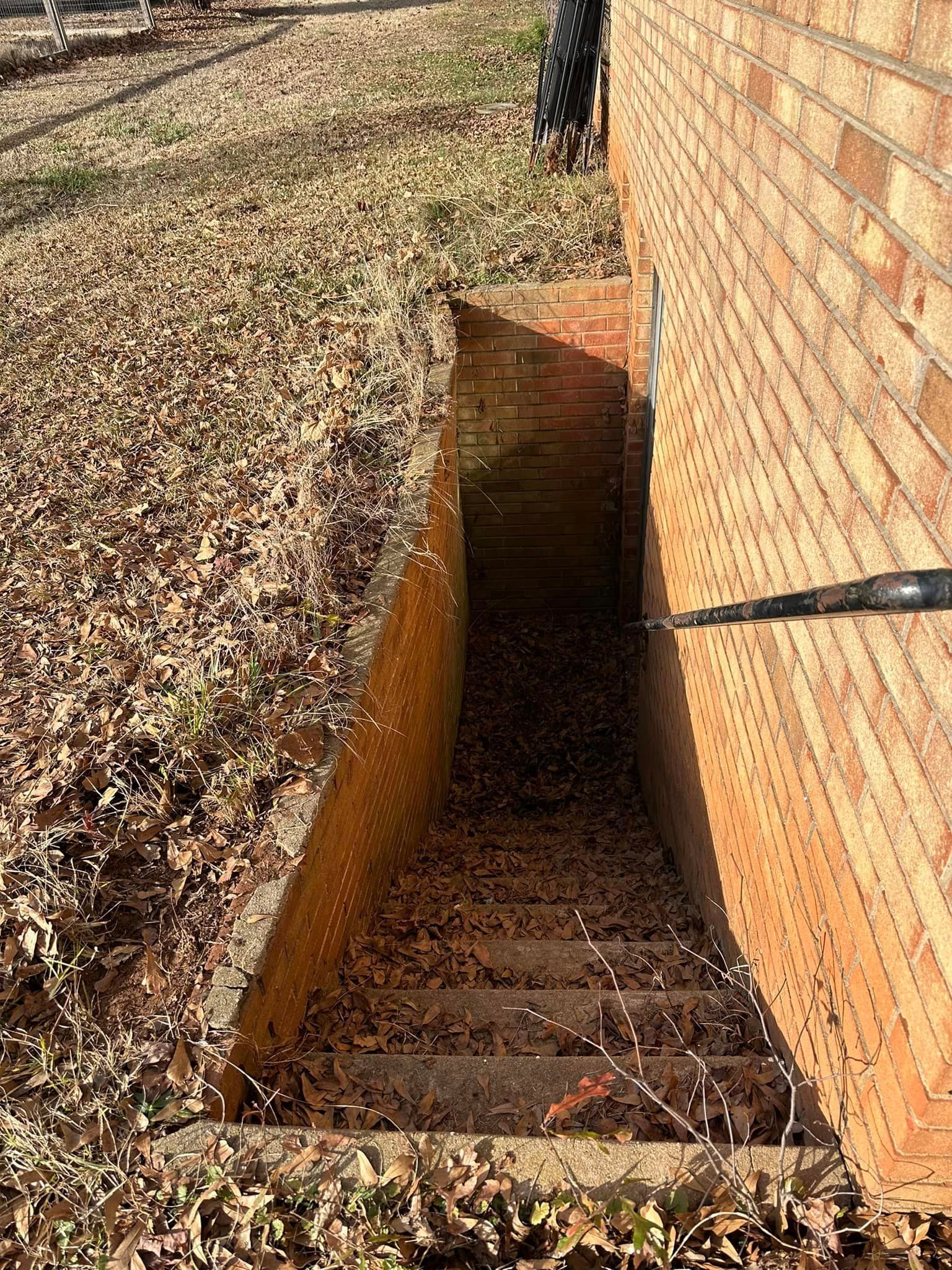 A brick wall with a hole in it and stairs leading up to it.
