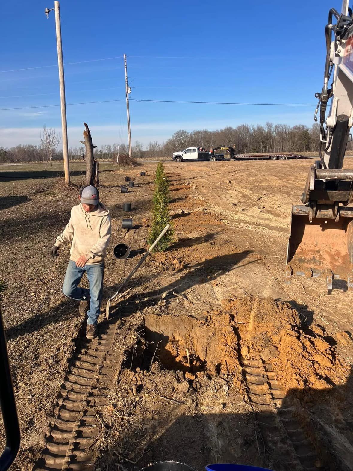 A man is digging a hole in the dirt with a shovel.