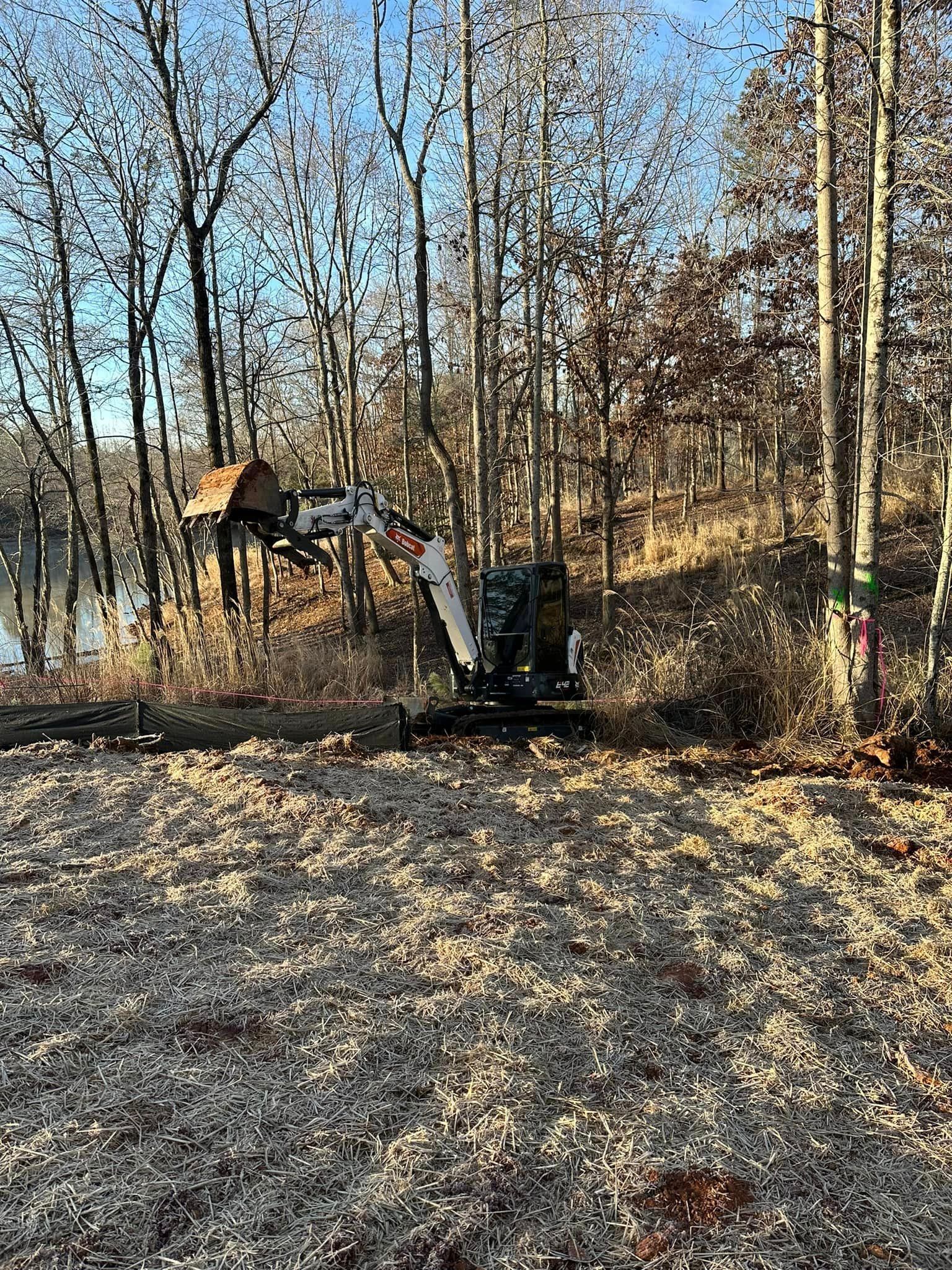 A machine is sitting in the middle of a forest next to a body of water.
