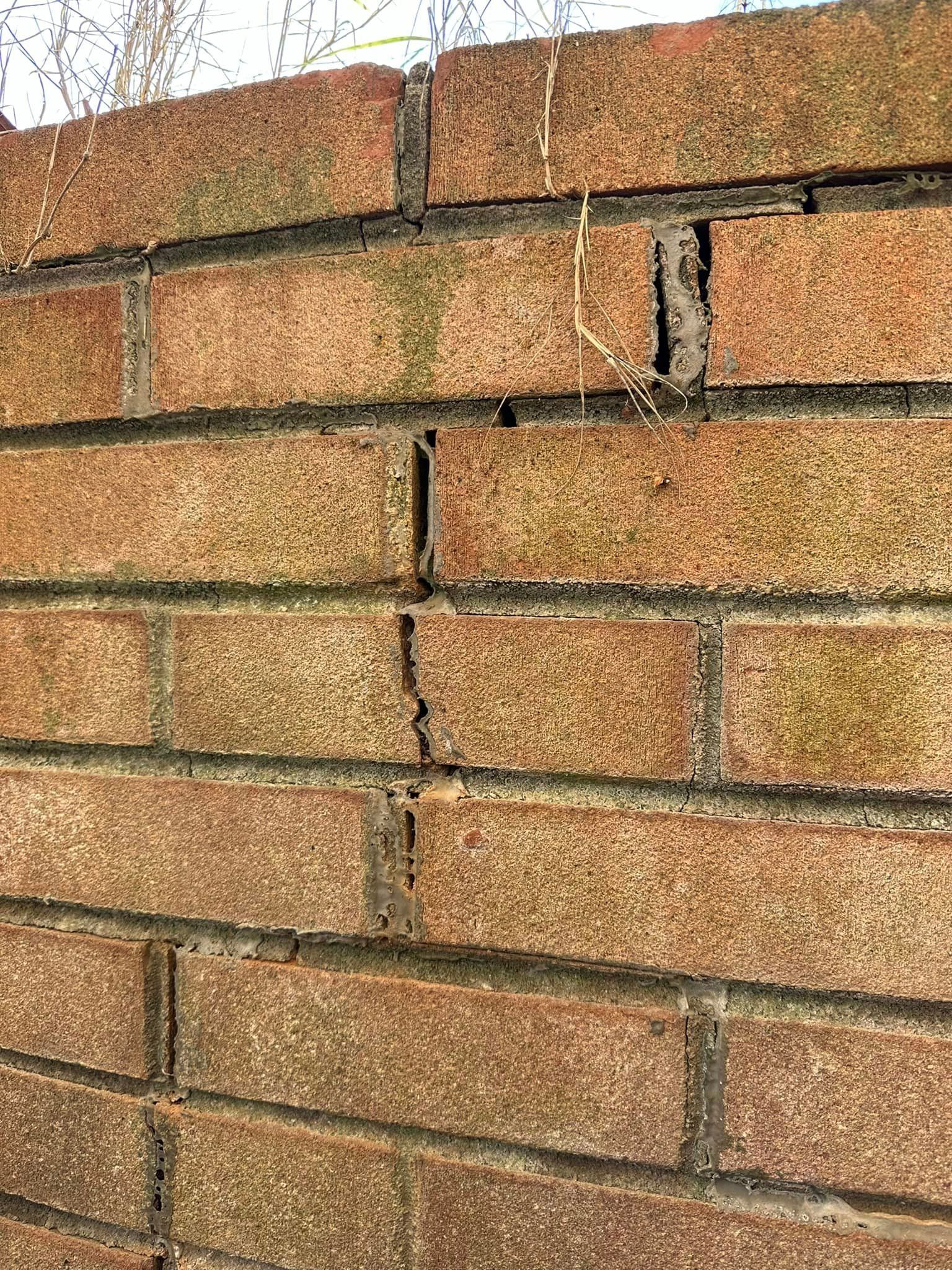 A close up of a cracked brick wall.