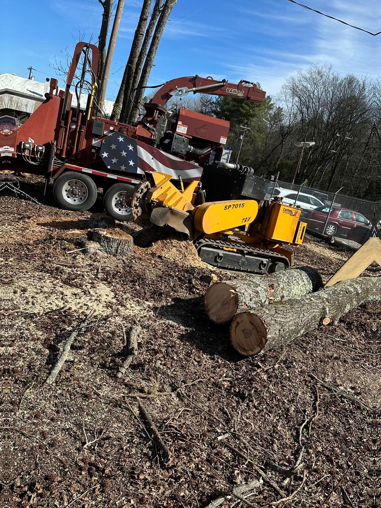 A tree stump is being removed by a machine in a field.