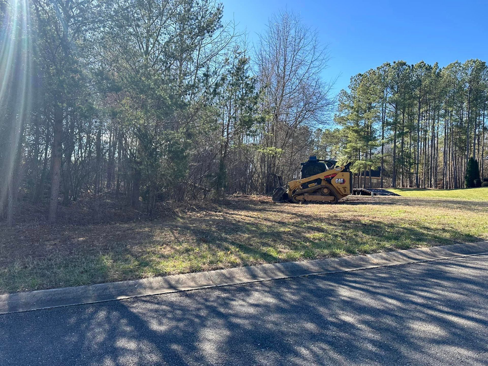 A bulldozer is sitting in the middle of a lush green field.