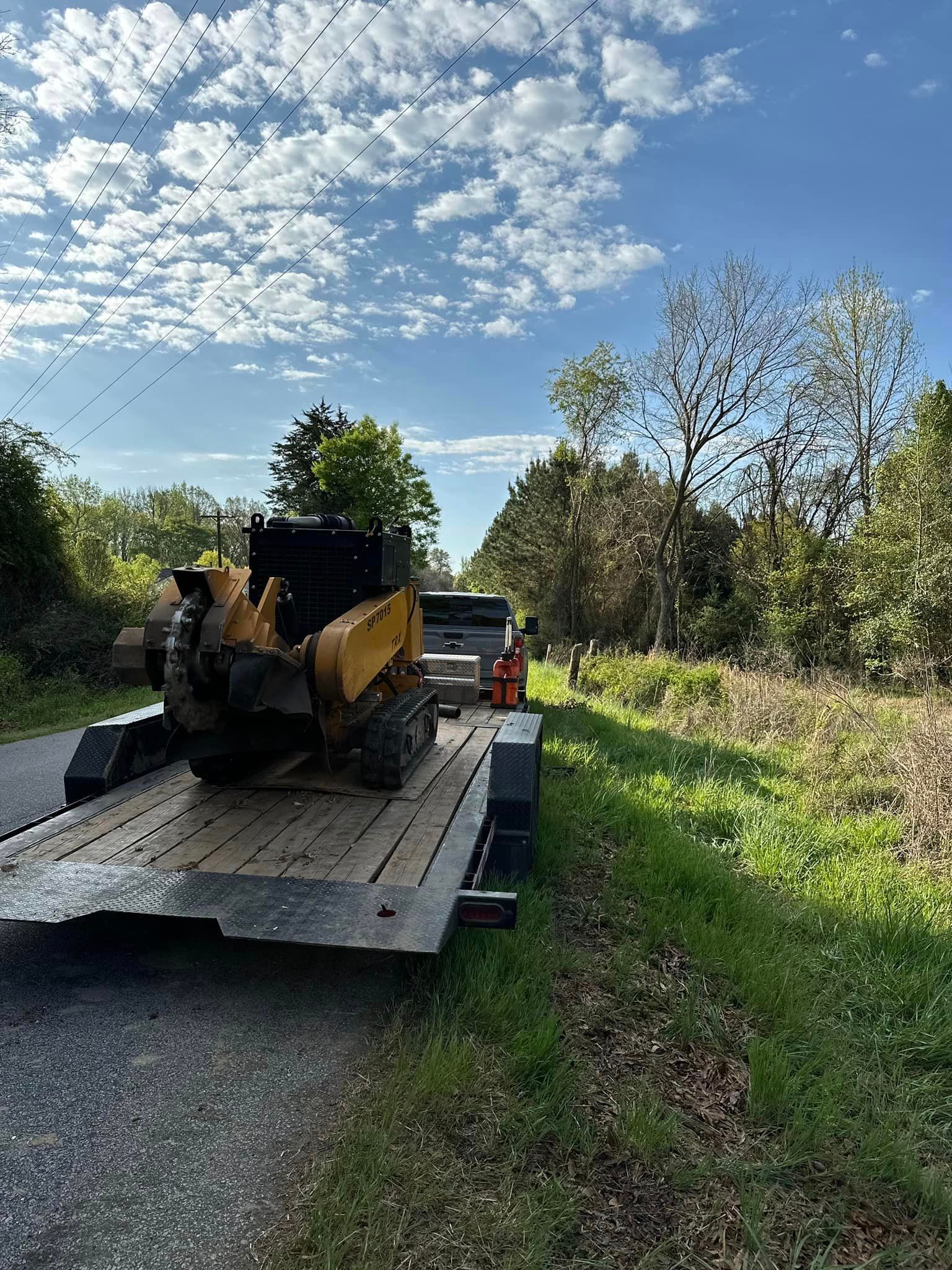 A stump grinder is sitting on top of a trailer.