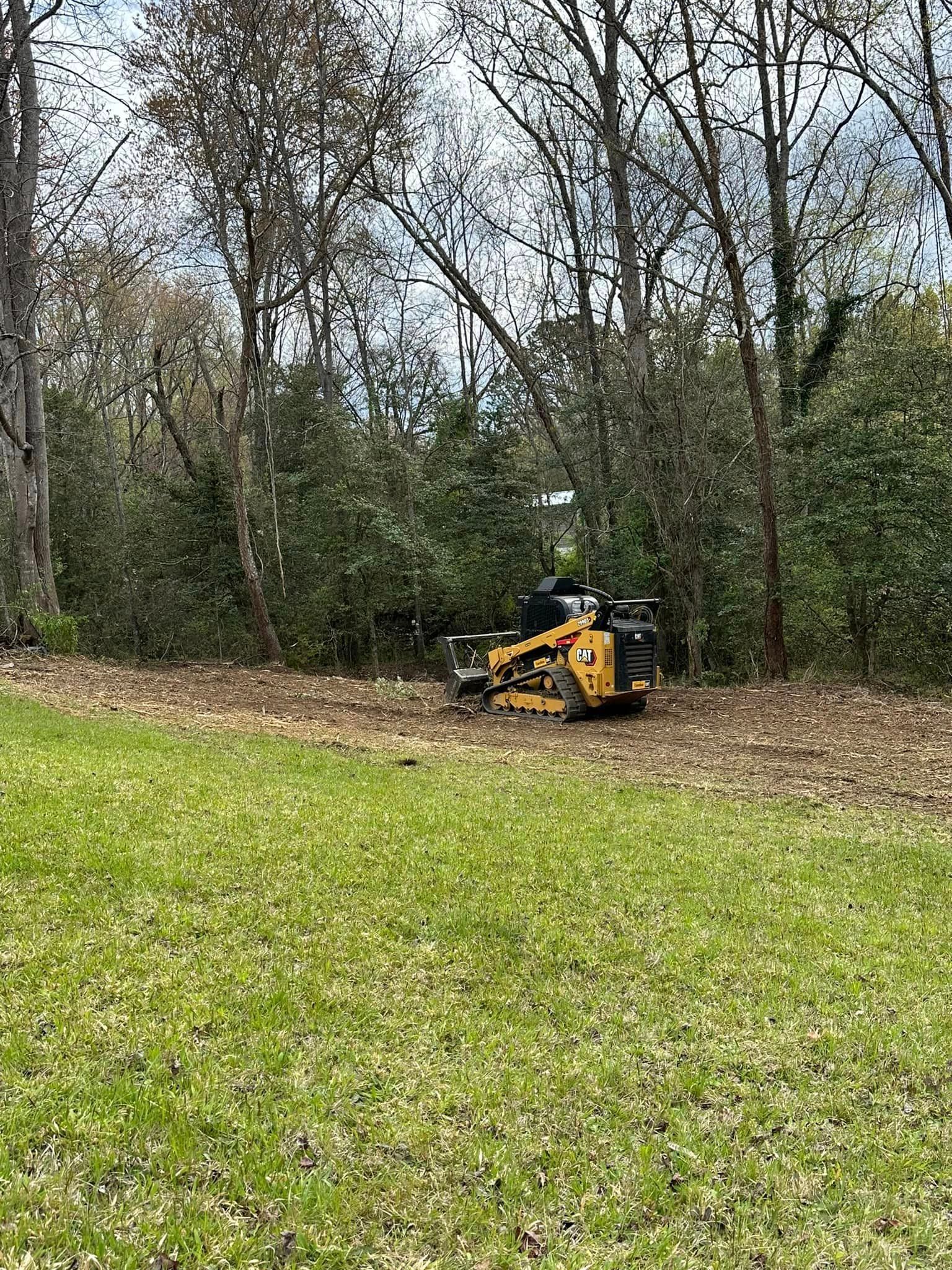 A yellow lawn mower is sitting in the middle of a lush green field.