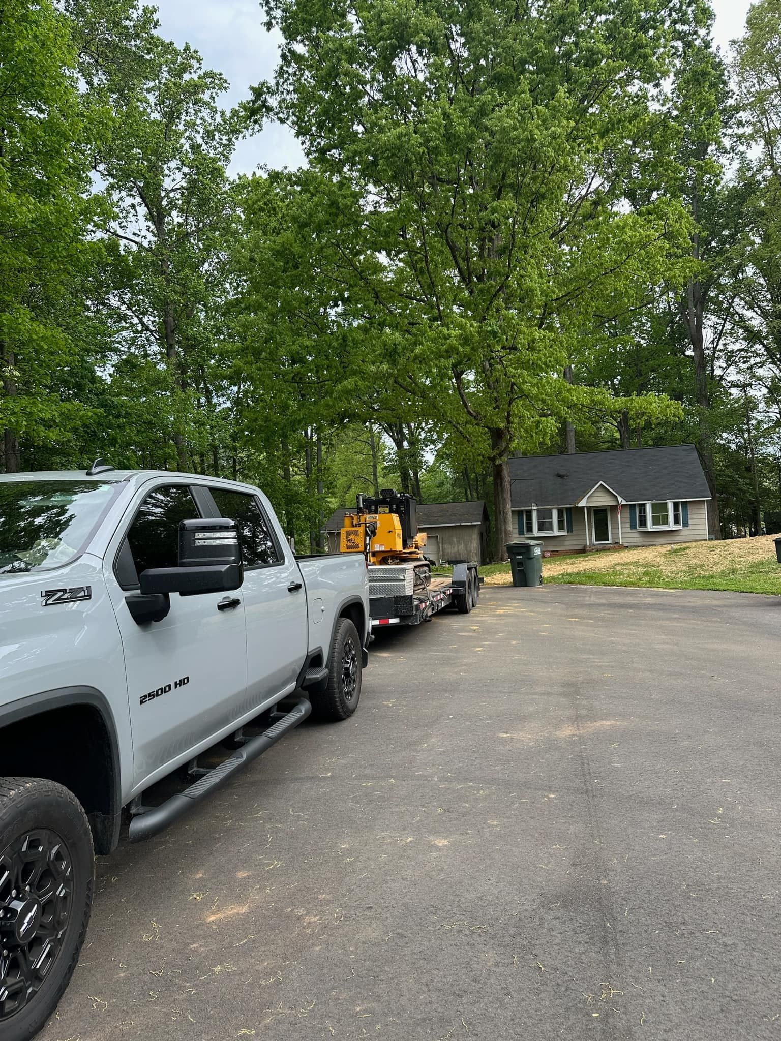A white truck is parked in a driveway next to a house.