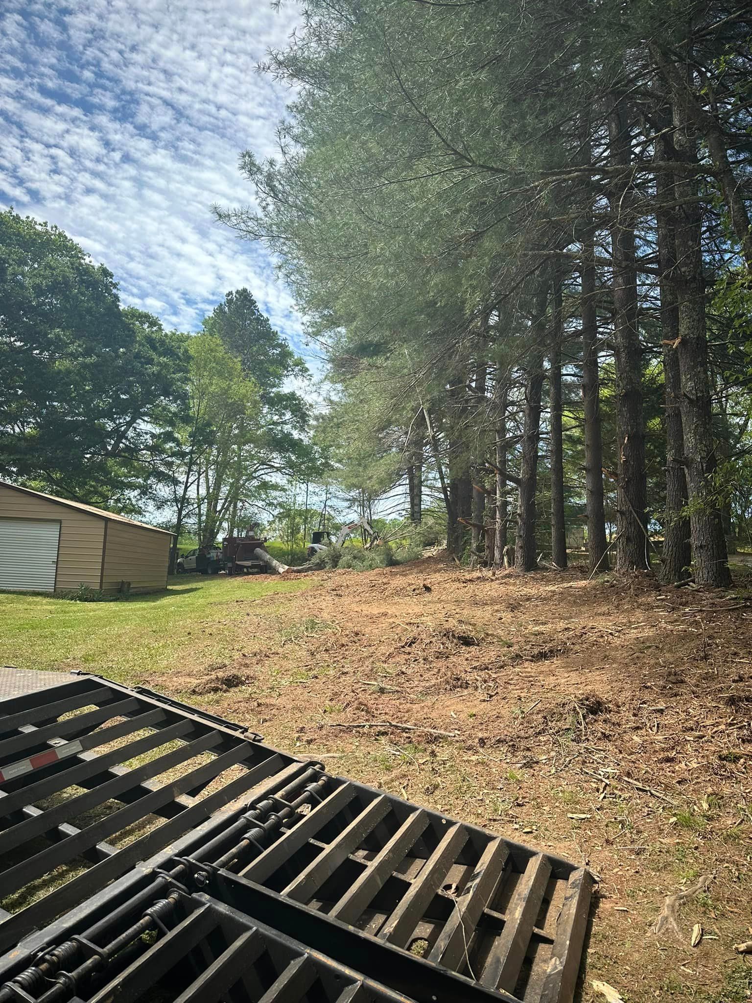 A wooden pallet is sitting in the middle of a field with trees in the background.