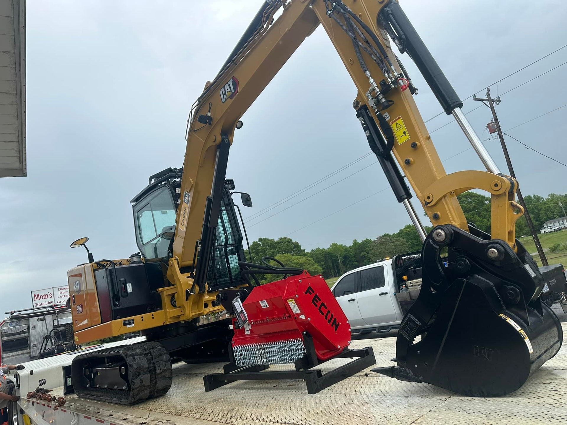 A large excavator is sitting on top of a dirt field.
