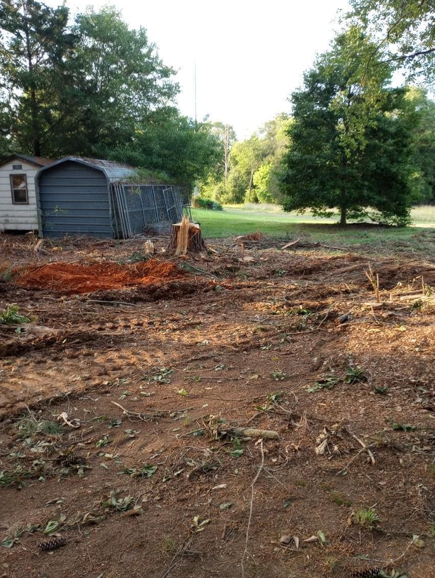 A shed is sitting in the middle of a dirt field.