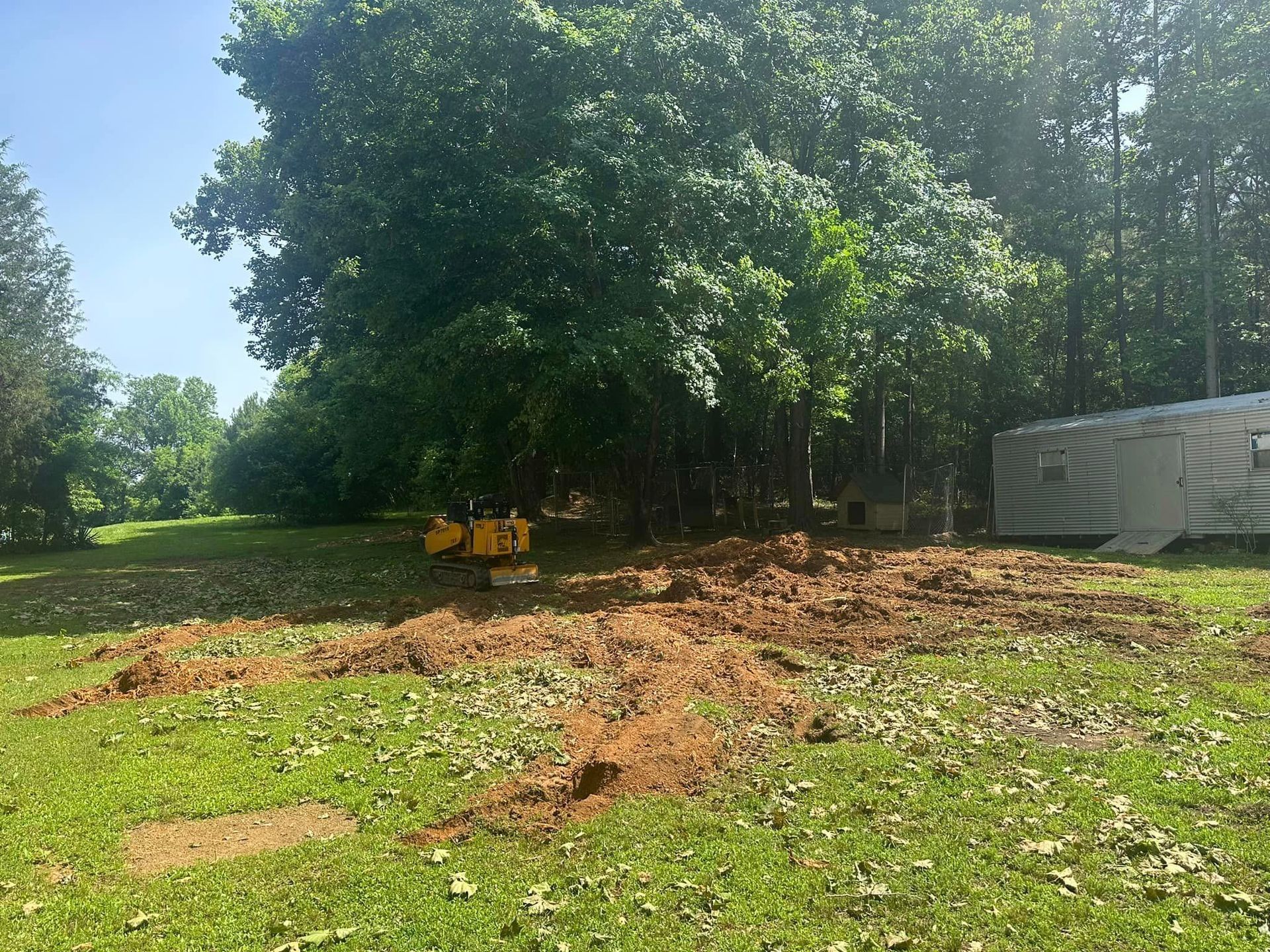 There is a trailer parked in the middle of a grassy field.