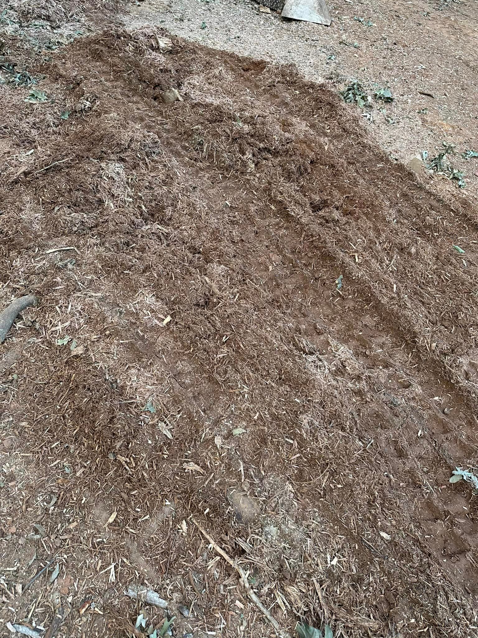 A pile of wood chips is sitting on the ground.