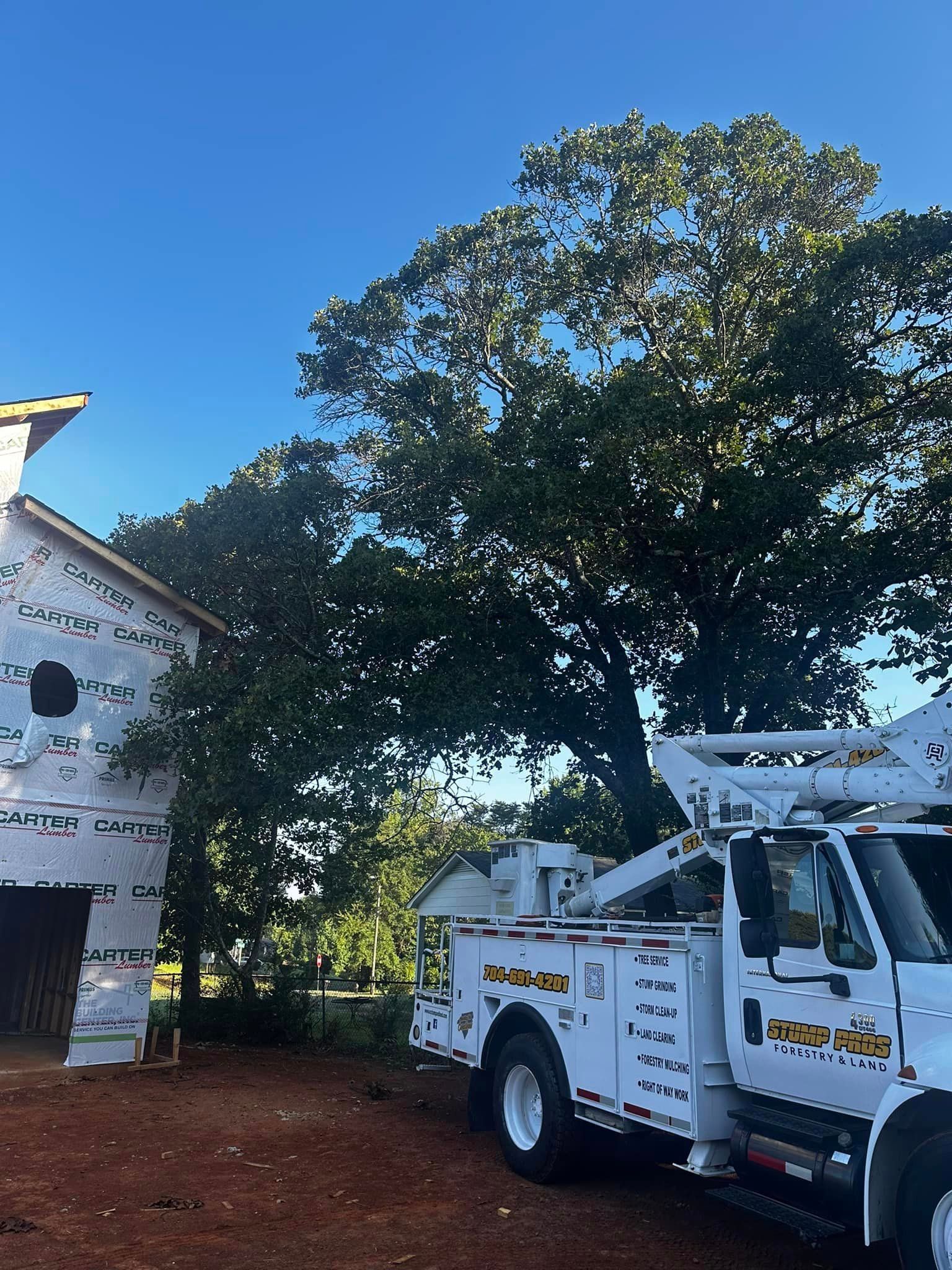 A white utility truck is parked in front of a building under construction.