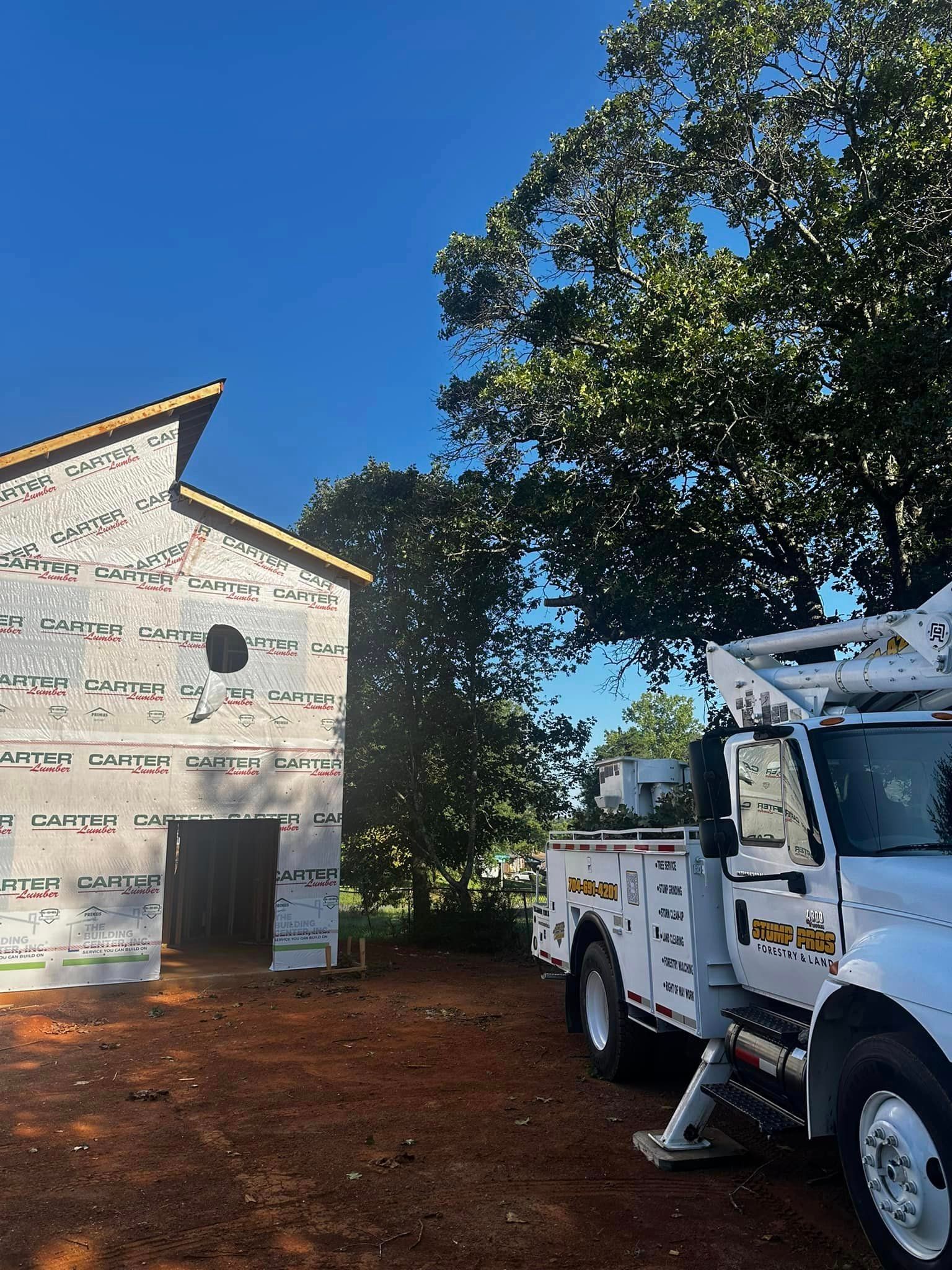 A white truck is parked in front of a building under construction.