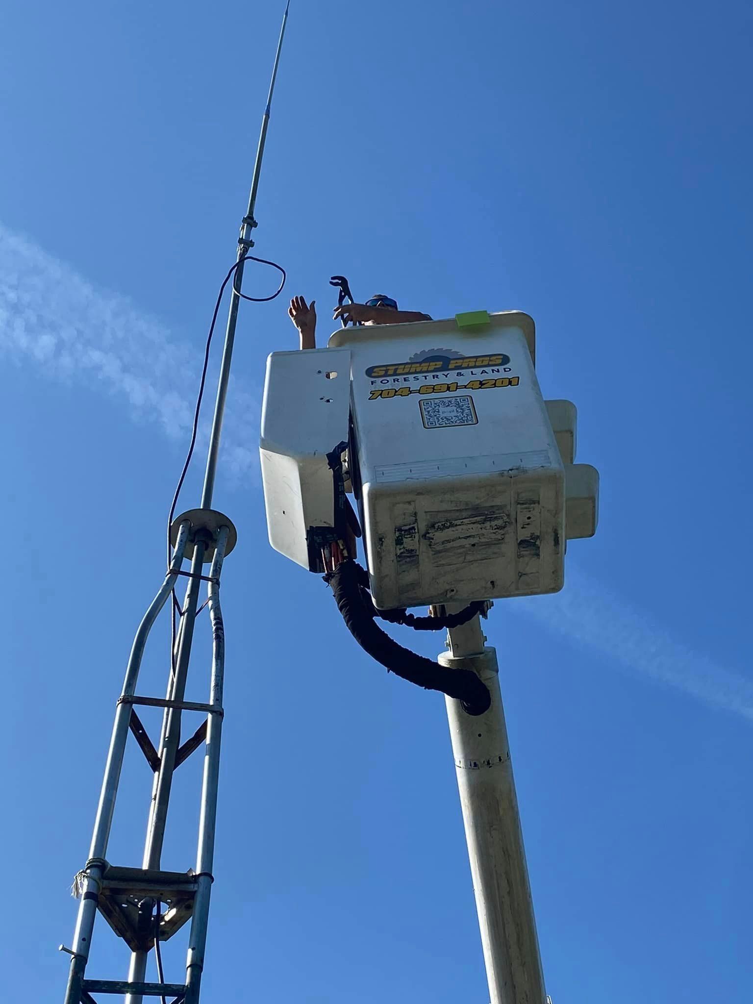 A man in a bucket is working on a power line