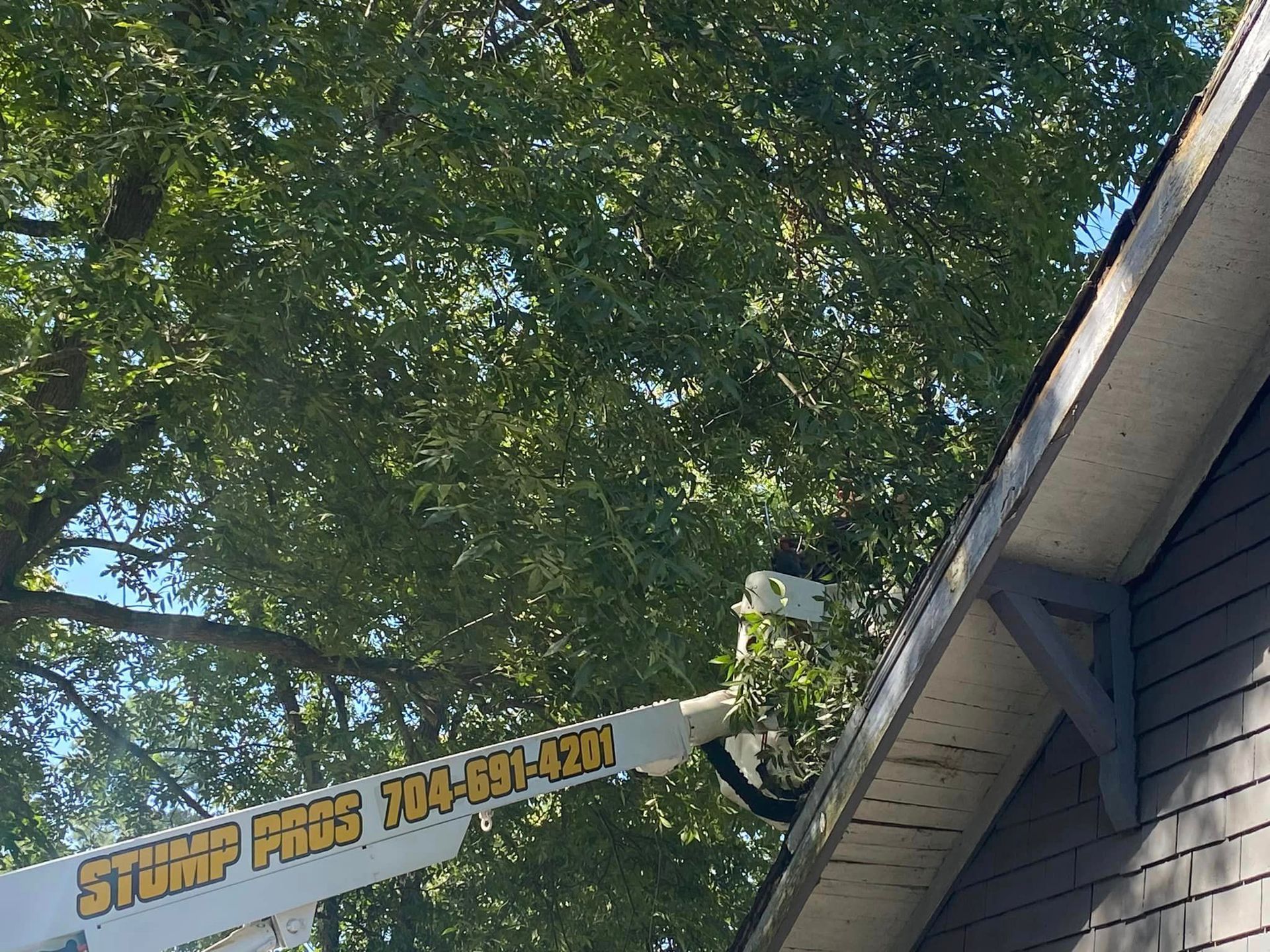 A crane is hanging from the roof of a house.