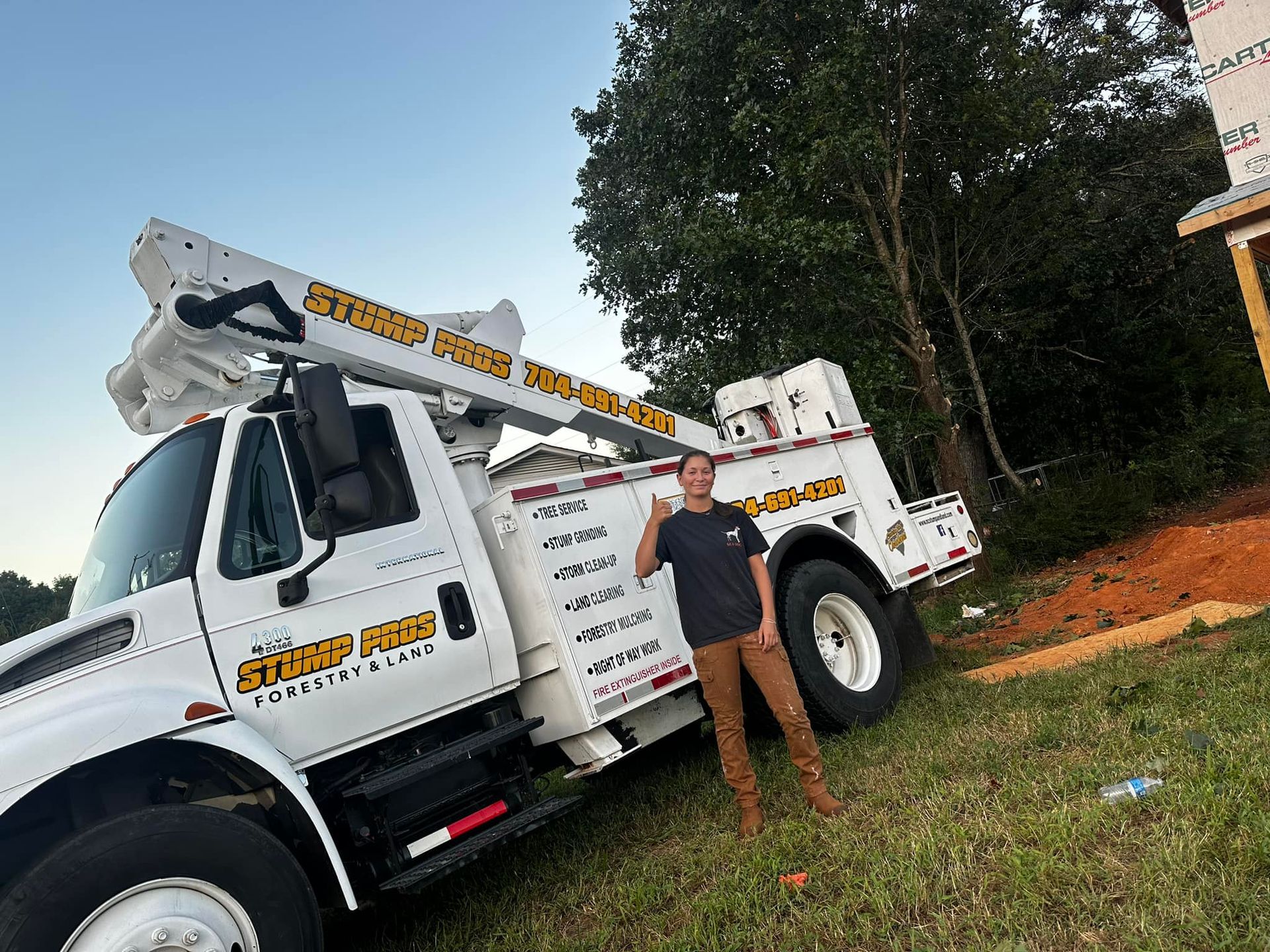 A man is standing in front of a large white truck.