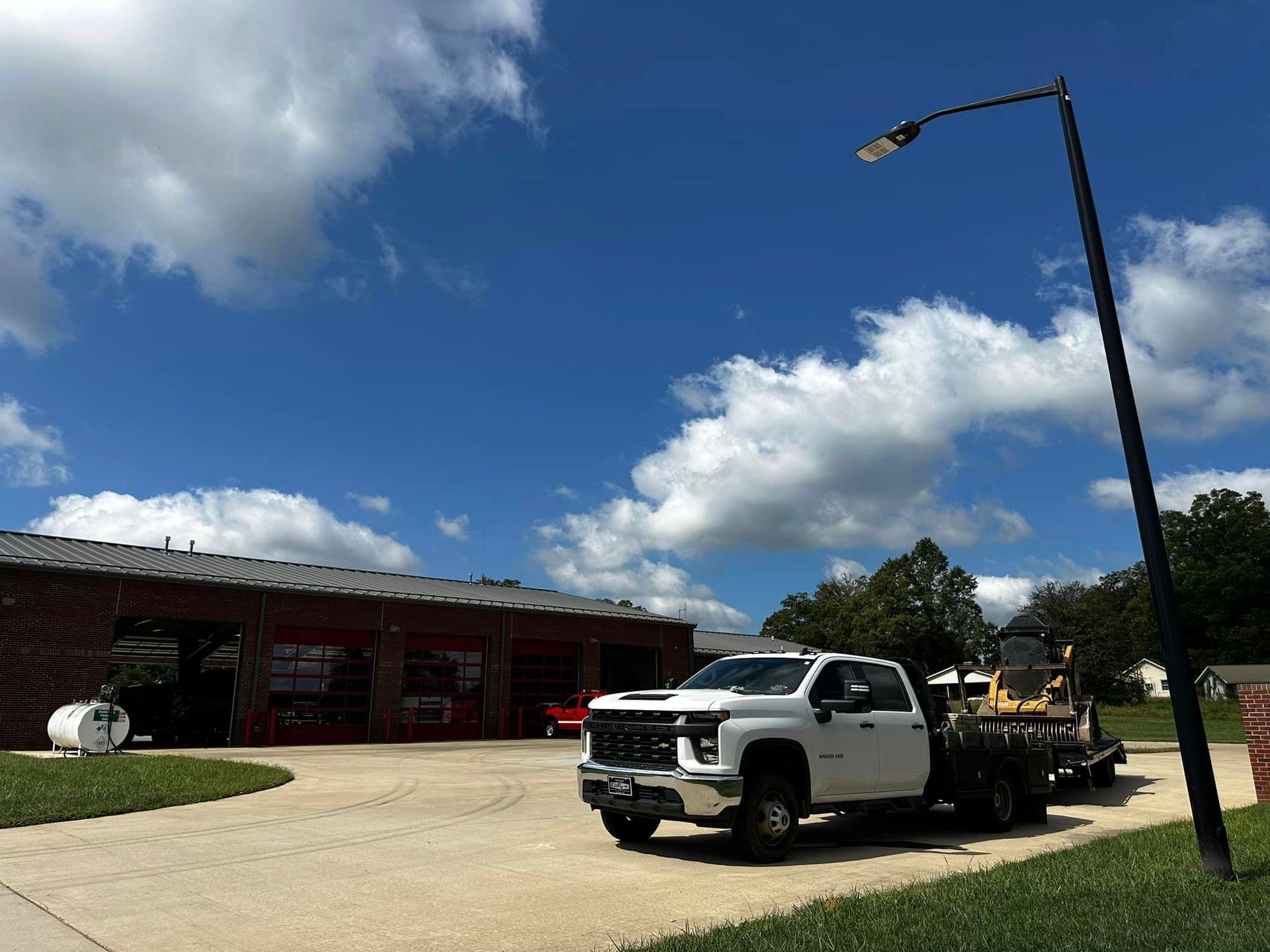 A white truck is parked in front of a building on a sunny day.