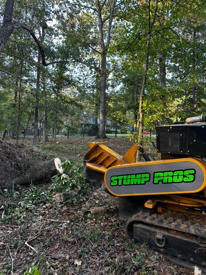 A stump grinder is sitting in the middle of a forest.