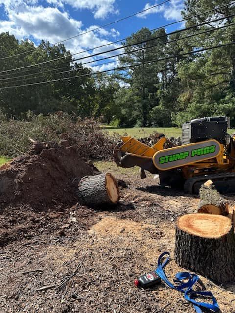 A stump grinder is cutting a tree stump in the dirt.