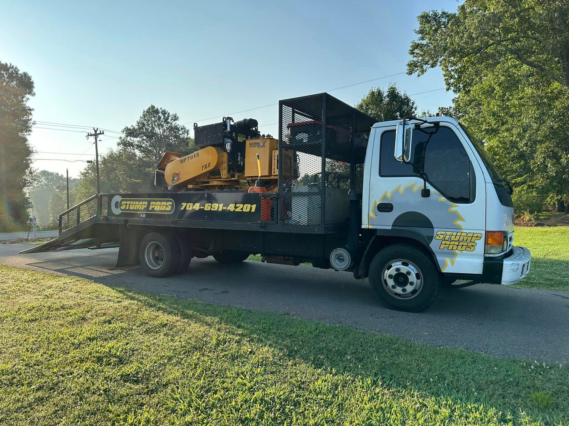 A tow truck with a crane on the back is parked on the side of the road.