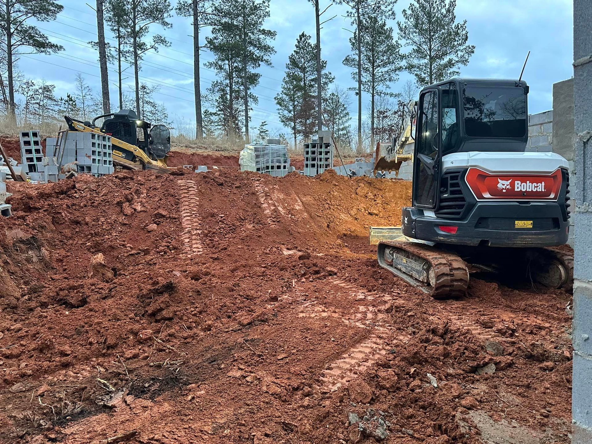 A bulldozer is driving through a pile of dirt on a construction site.