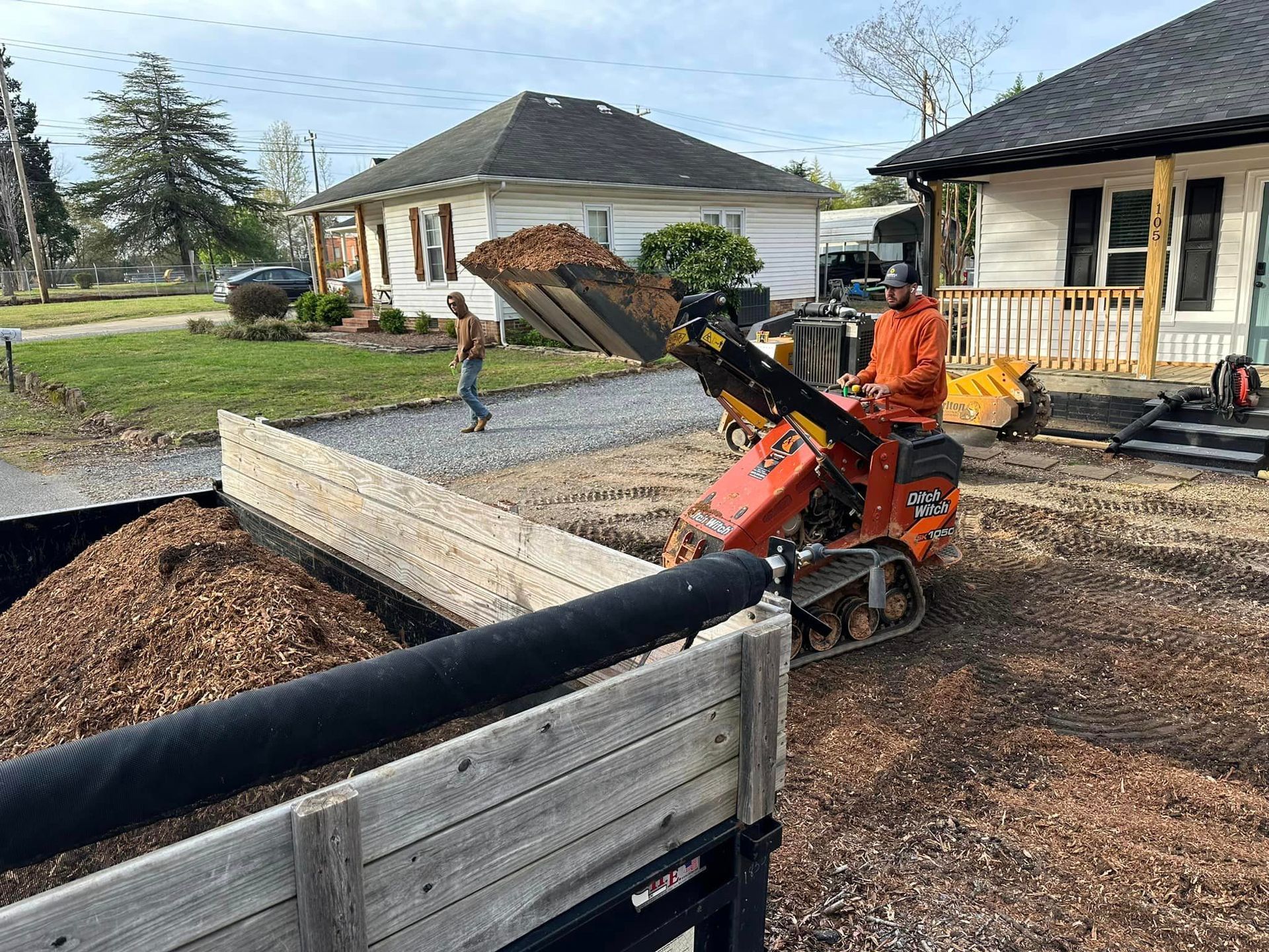 A man is loading wood chips into a truck.