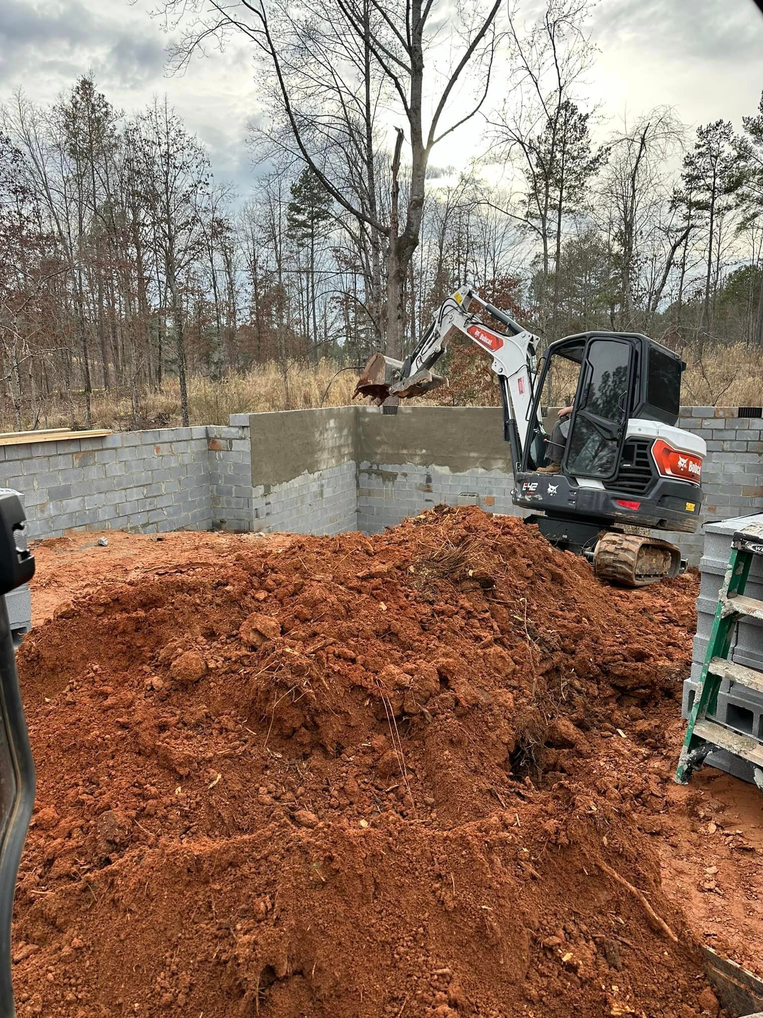 A bulldozer is digging a hole in a pile of dirt.