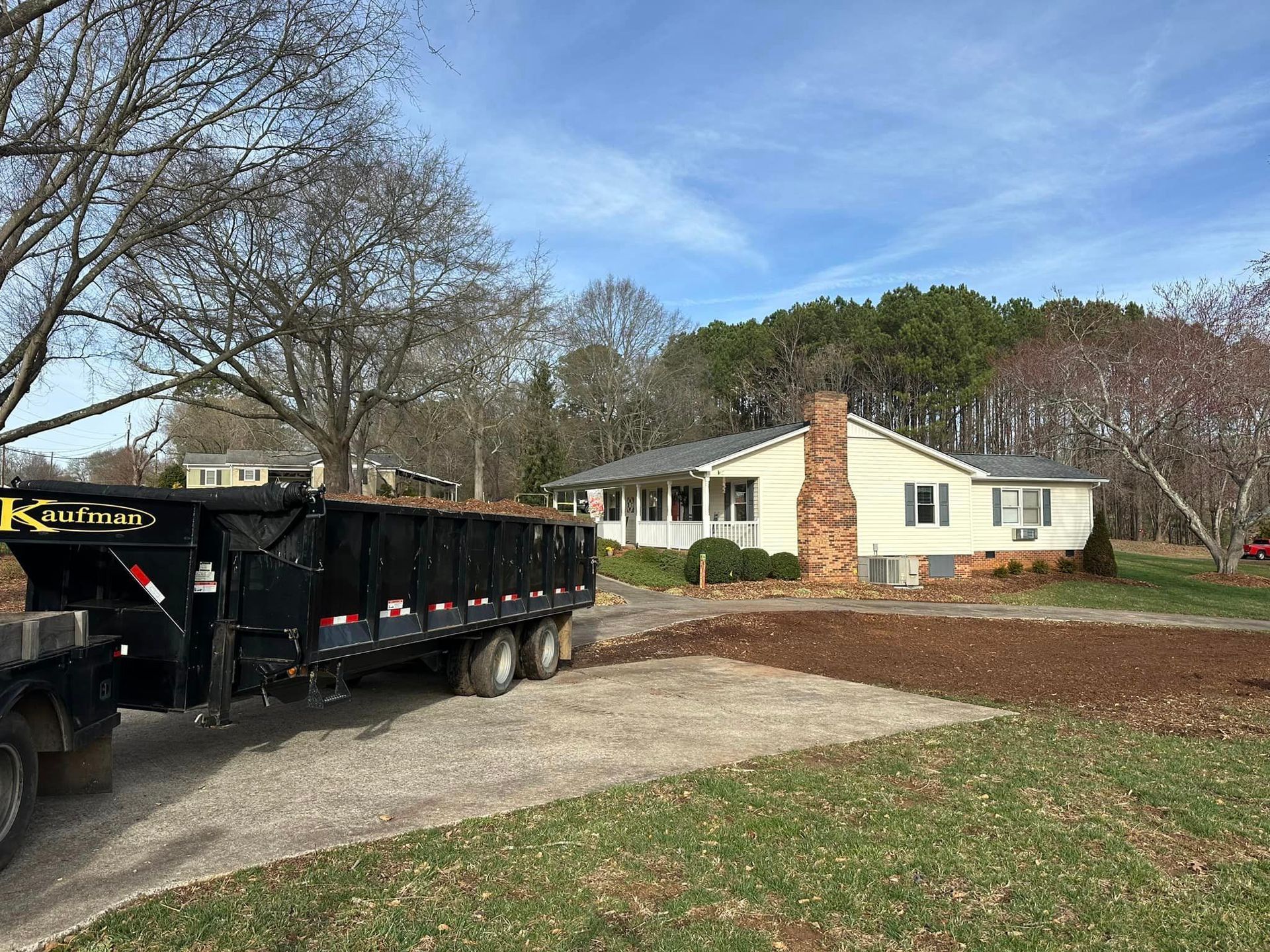 A dump truck is parked in front of a house.