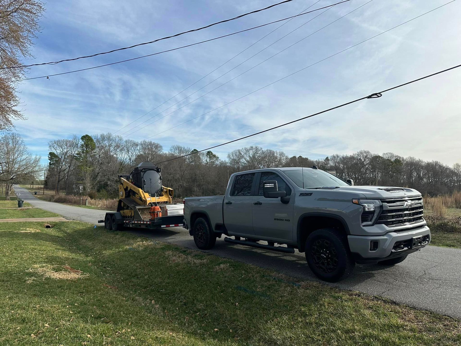 A truck with a trailer attached to it is parked on the side of the road.