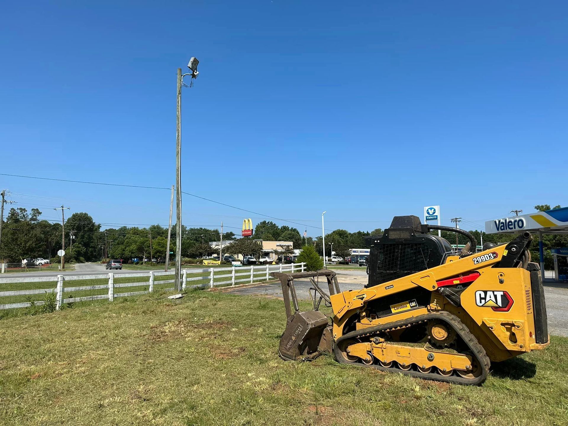 A yellow bulldozer is parked in a grassy field.