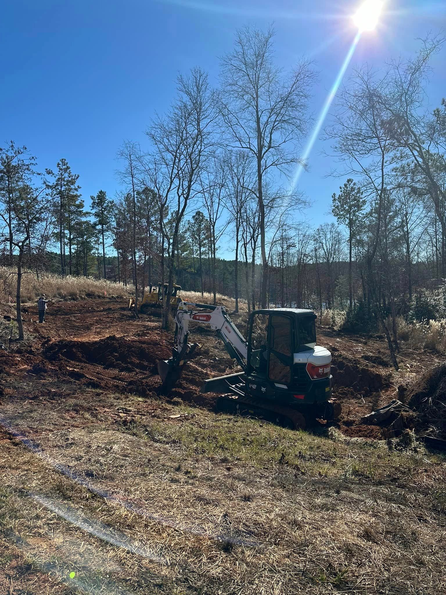 A small excavator is sitting in the middle of a field.