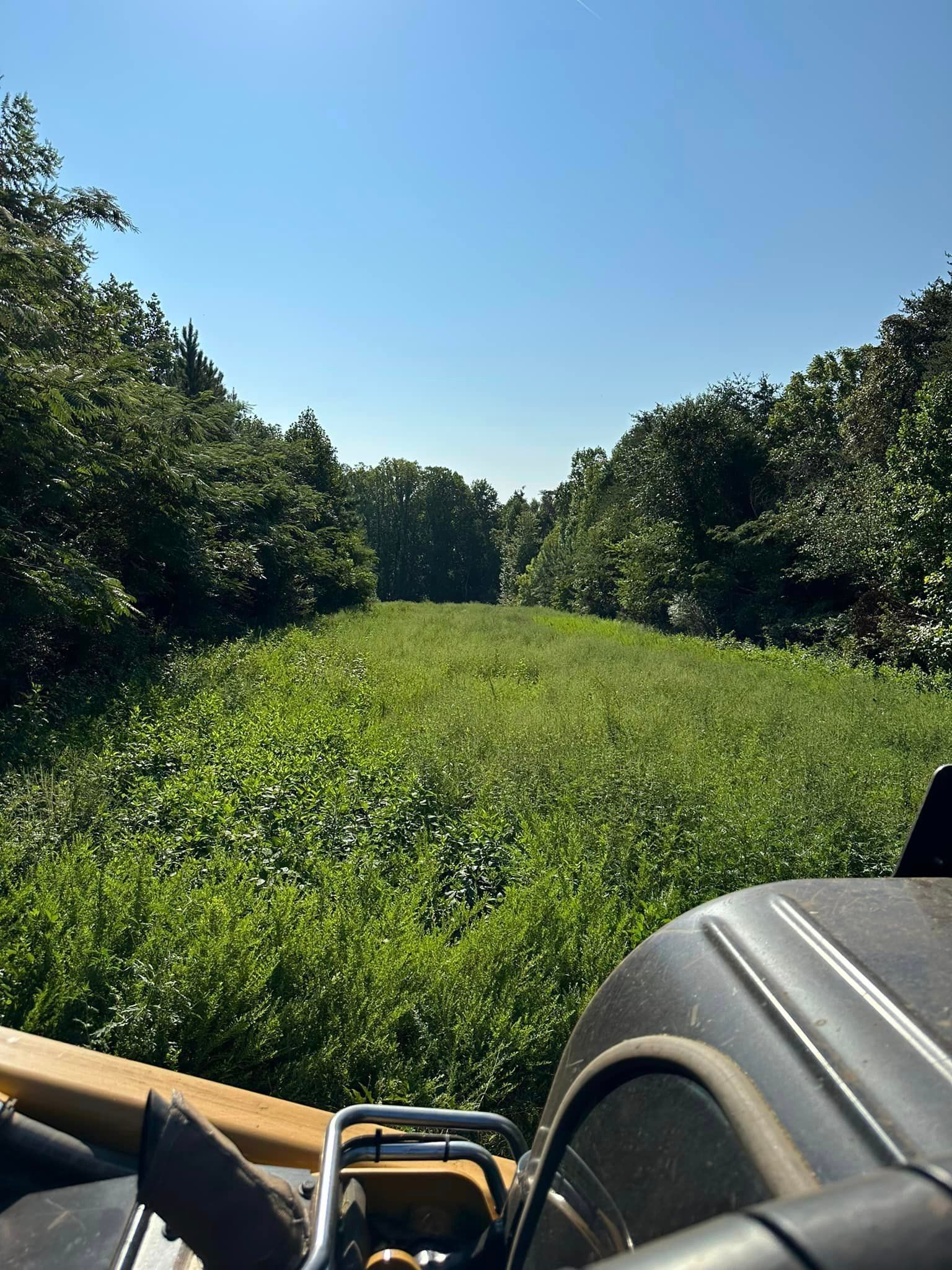 A person is riding a motorcycle through a grassy field.