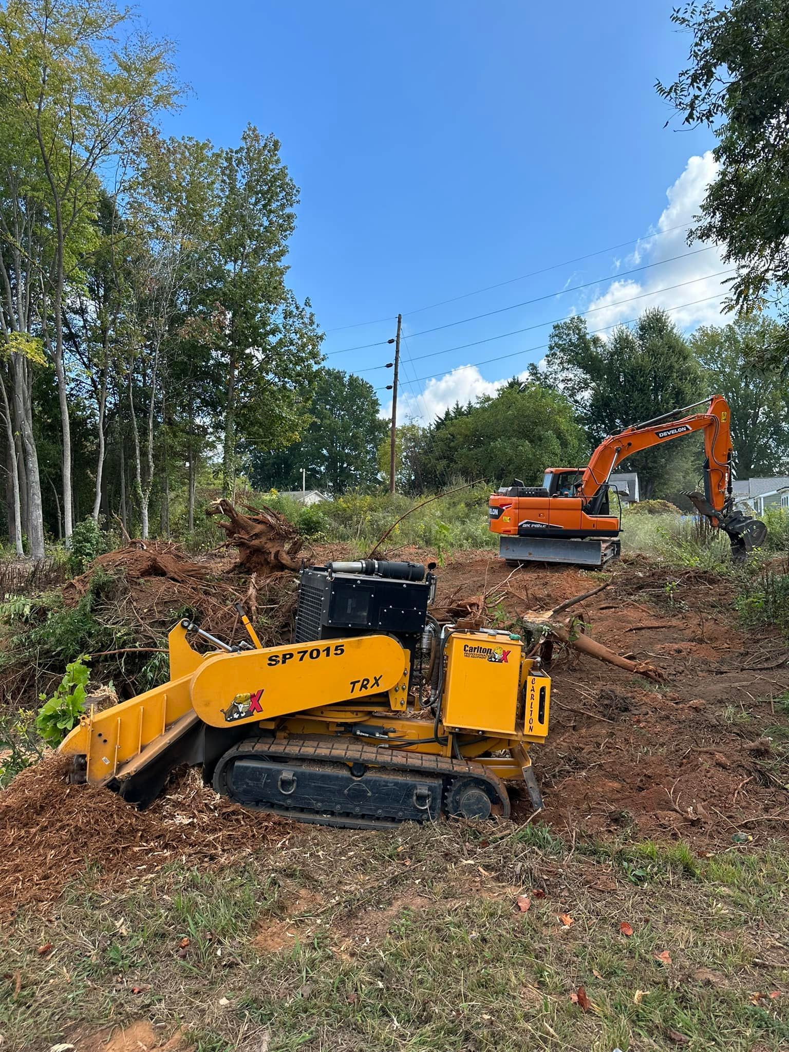A bulldozer and an excavator are working on a dirt field.