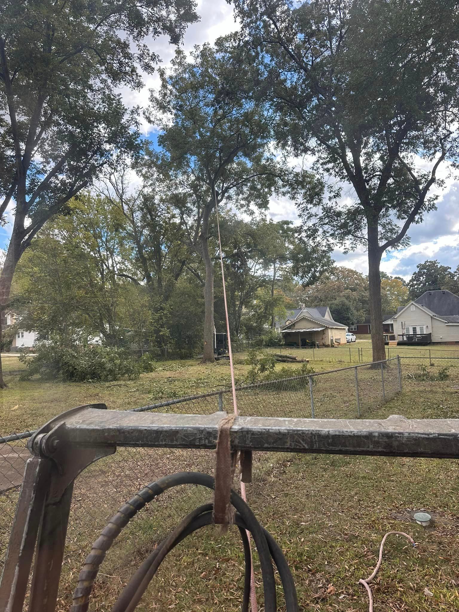 A fence is sitting in the middle of a field with trees in the background.