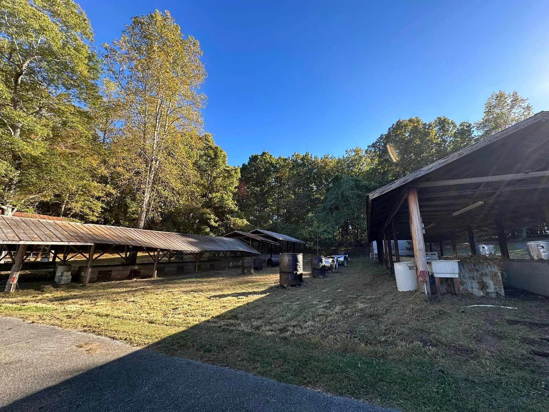 A large shed is sitting in the middle of a grassy field.