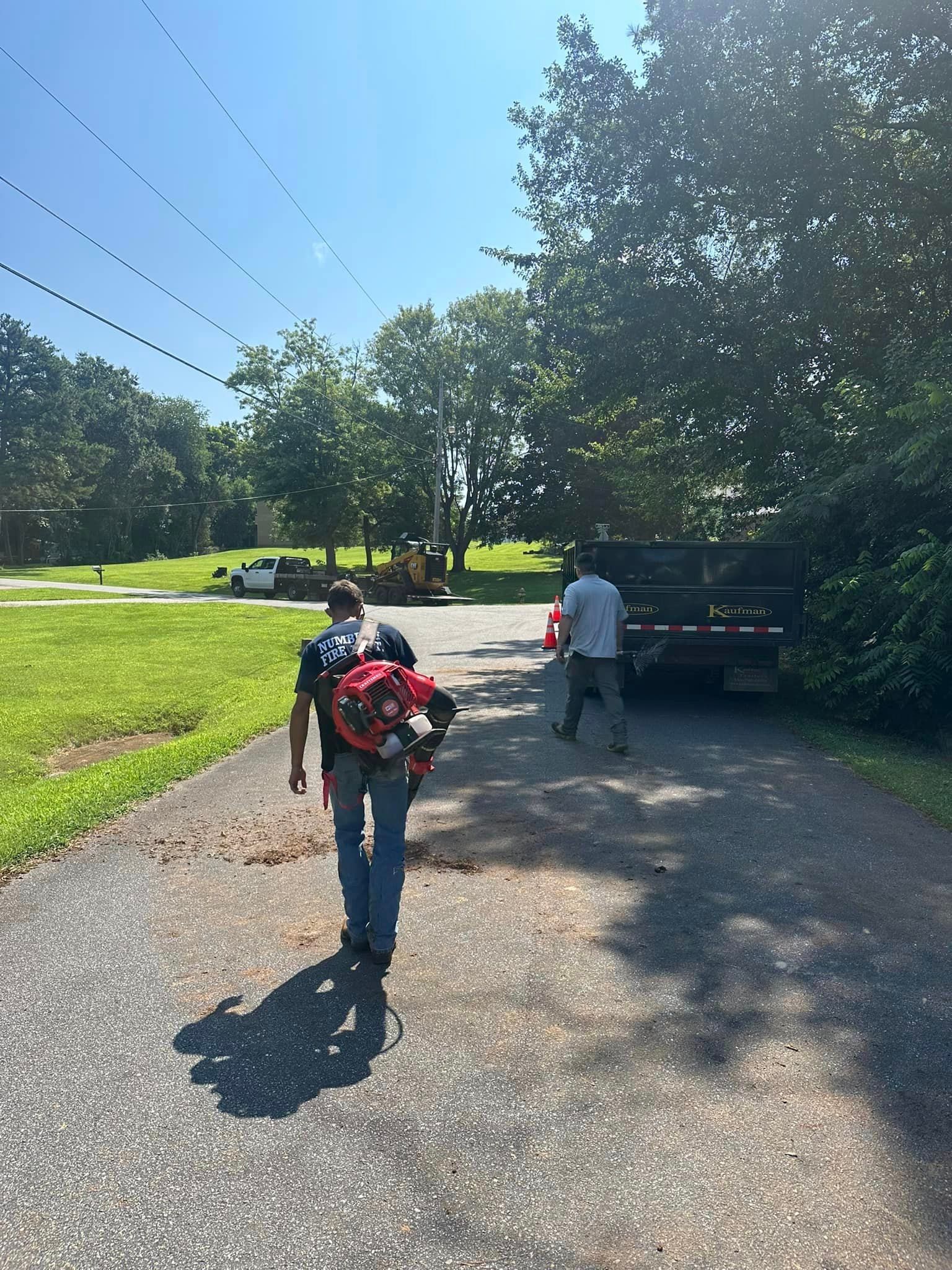 A man with a backpack is walking down a road.