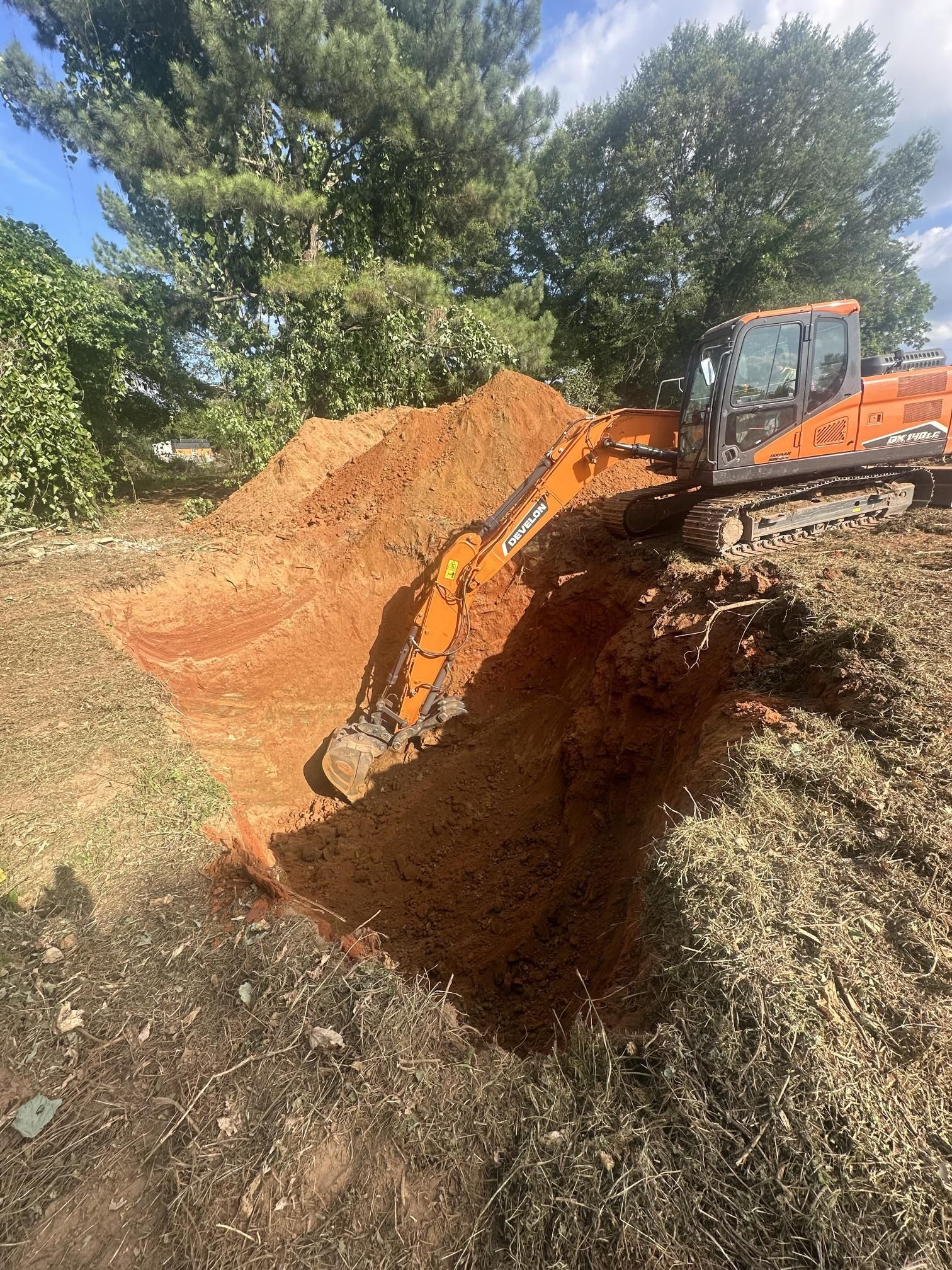 A bulldozer is digging a hole in the ground in a field.