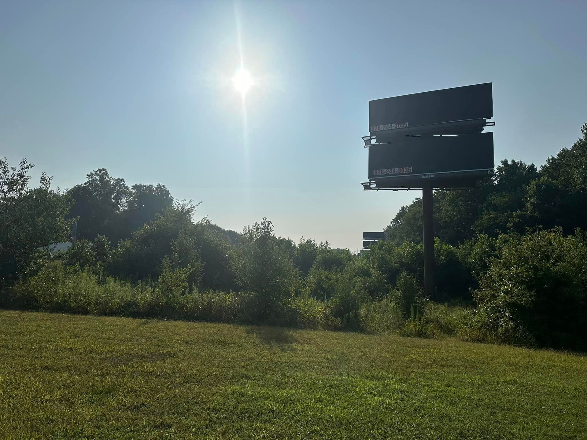 A large billboard in the middle of a grassy field