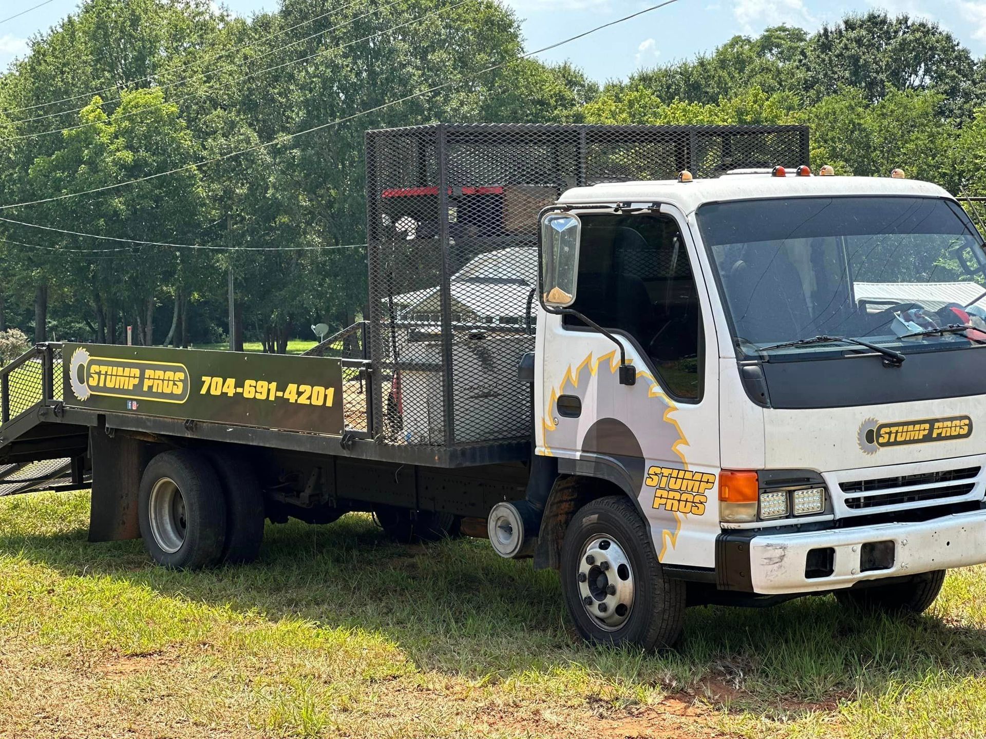 A white tow truck is parked in a grassy field.