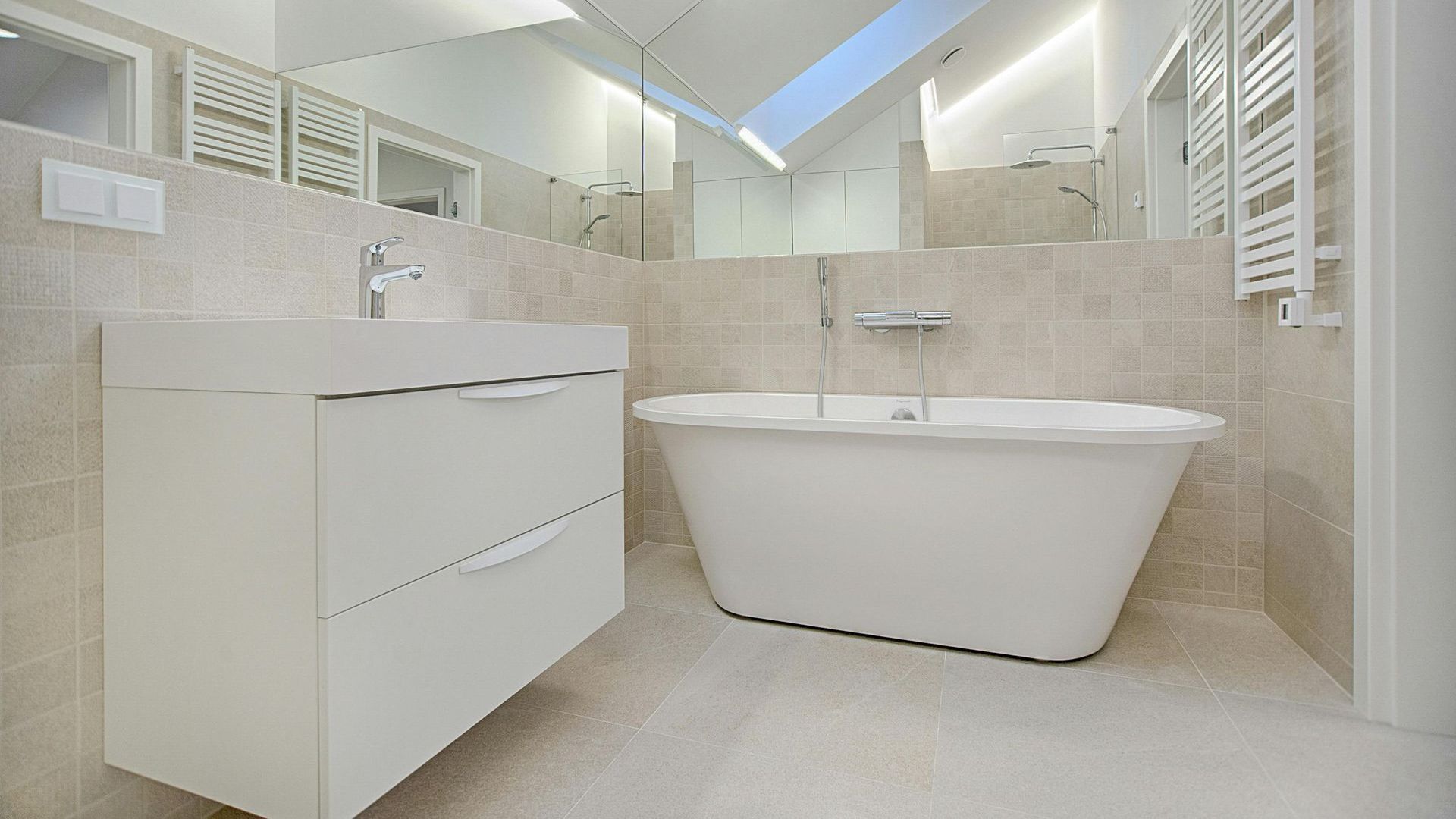 A bathroom with a bathtub , sink and mirror.