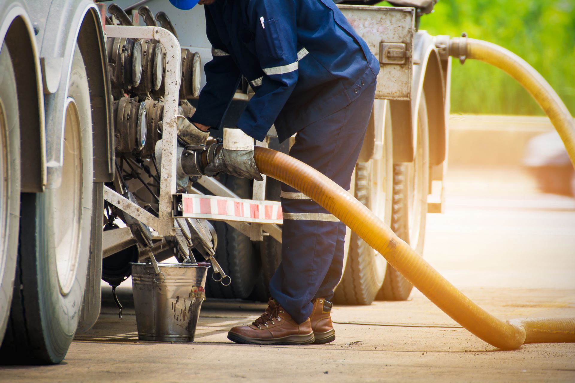 A man is pumping gas into a truck with a hose.