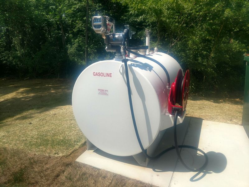 Two fuel tanks are connected to a truck in front of a building